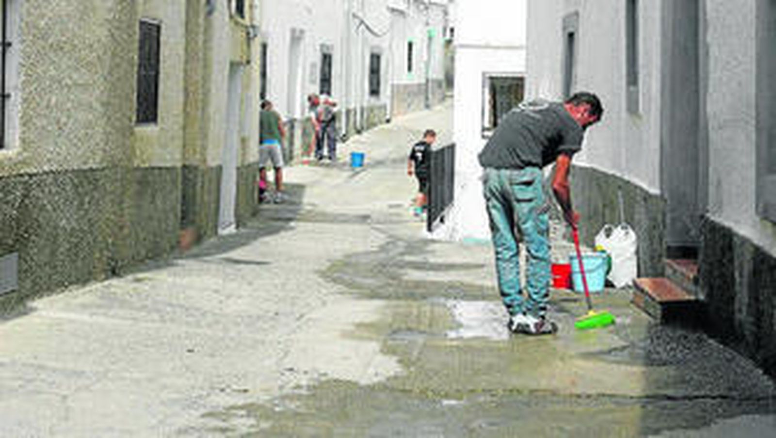 Un vecino limpia las manchas de sangre tras el asesinato ayer de una mujer en el municipio de Gérgal.