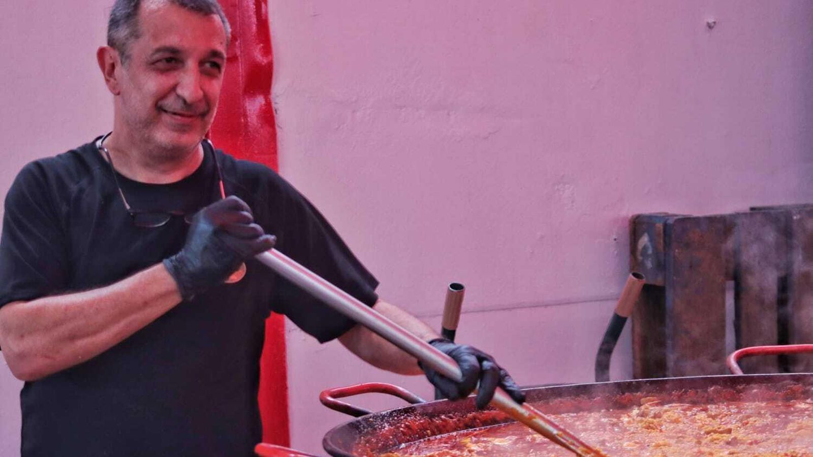 Cocinero de una caseta removiendo el arroz de la paella