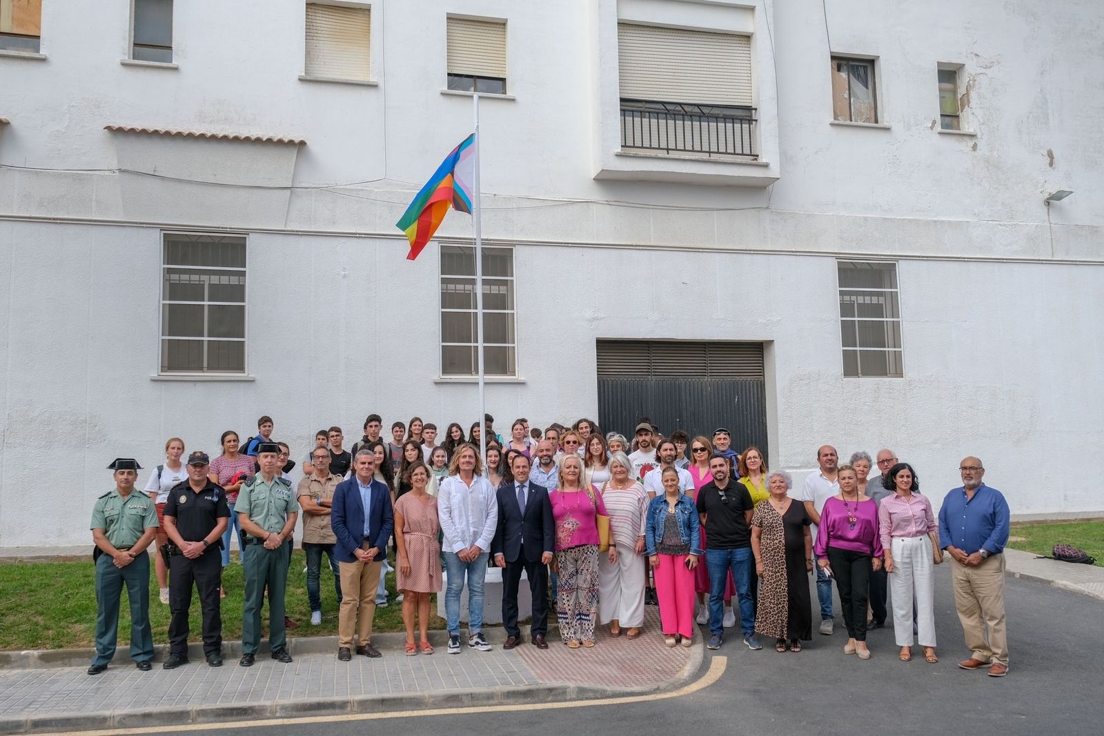 Miembros de la Corporación y del colectivo LGTBI+ junto a la bandera izada en la calle Diversidad.