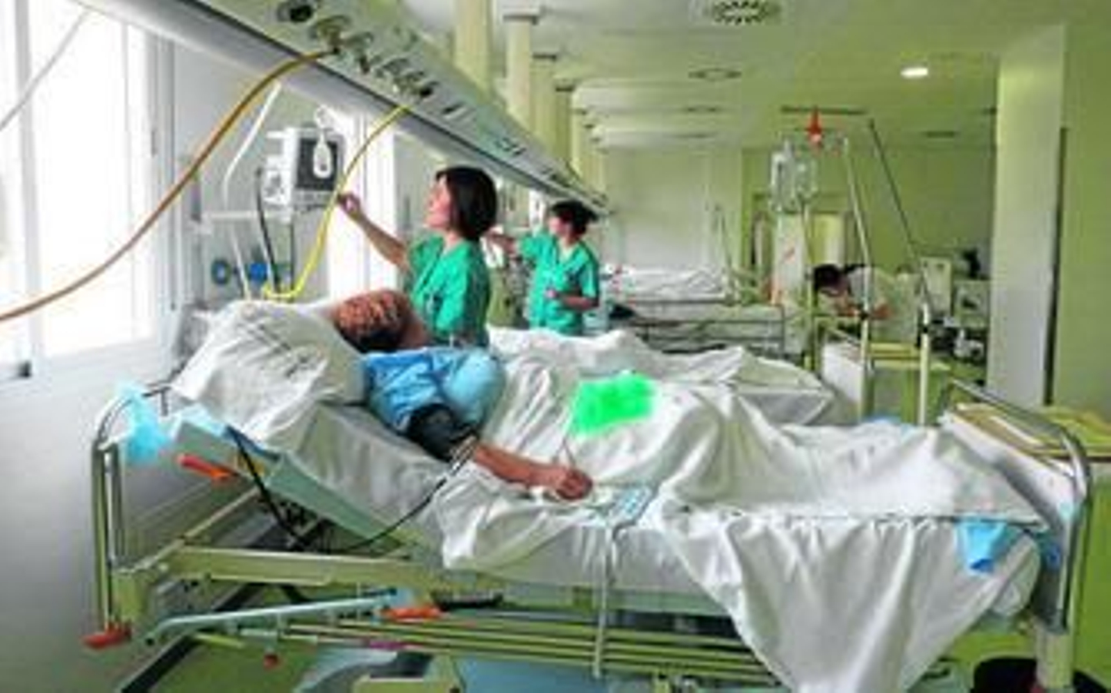 Dos trabajadoras de la Sanidad pública atienden a varios pacientes en el hospital Vázquez Díaz de Huelva.