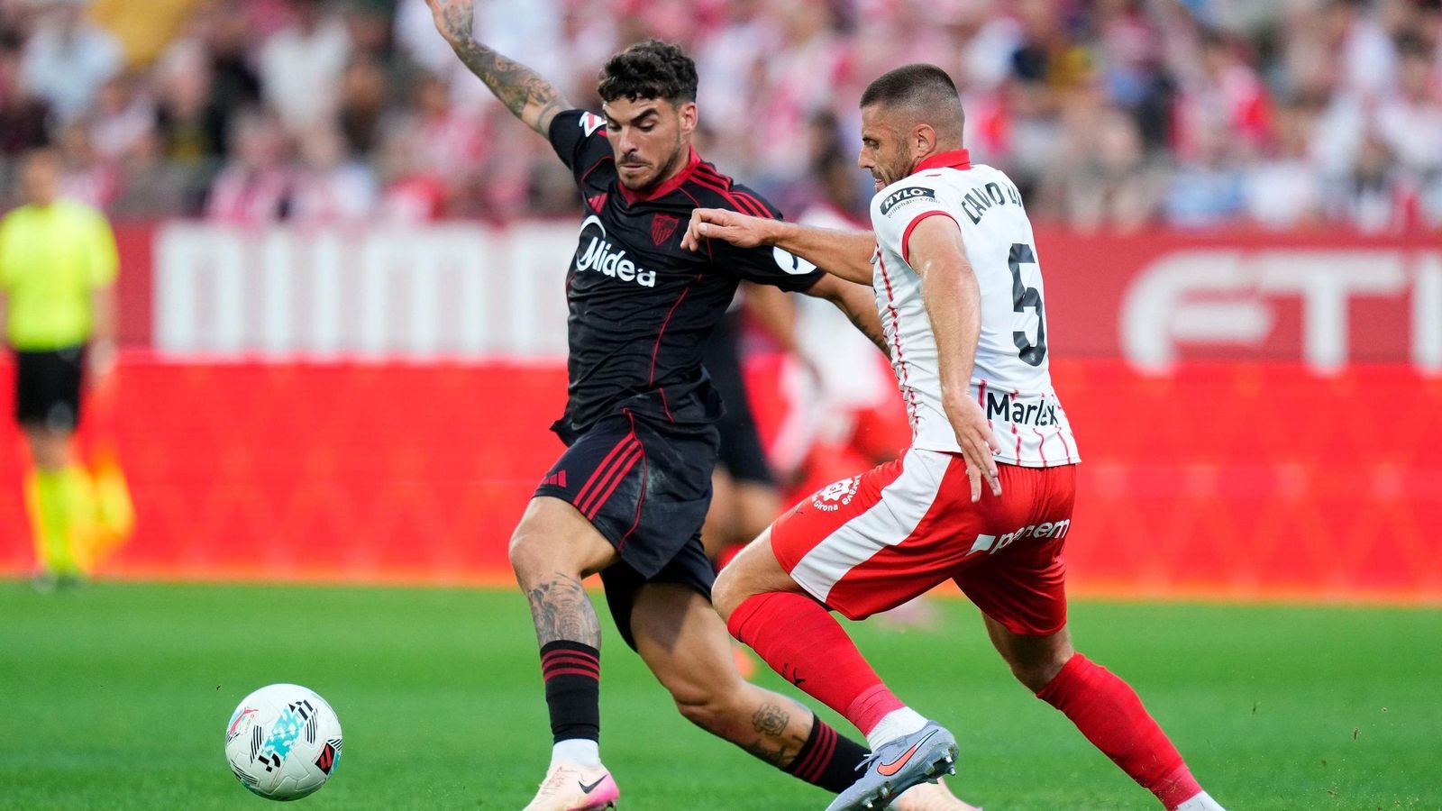 Isaac ante David López en el encuentro entre el Sevilla y el Girona.