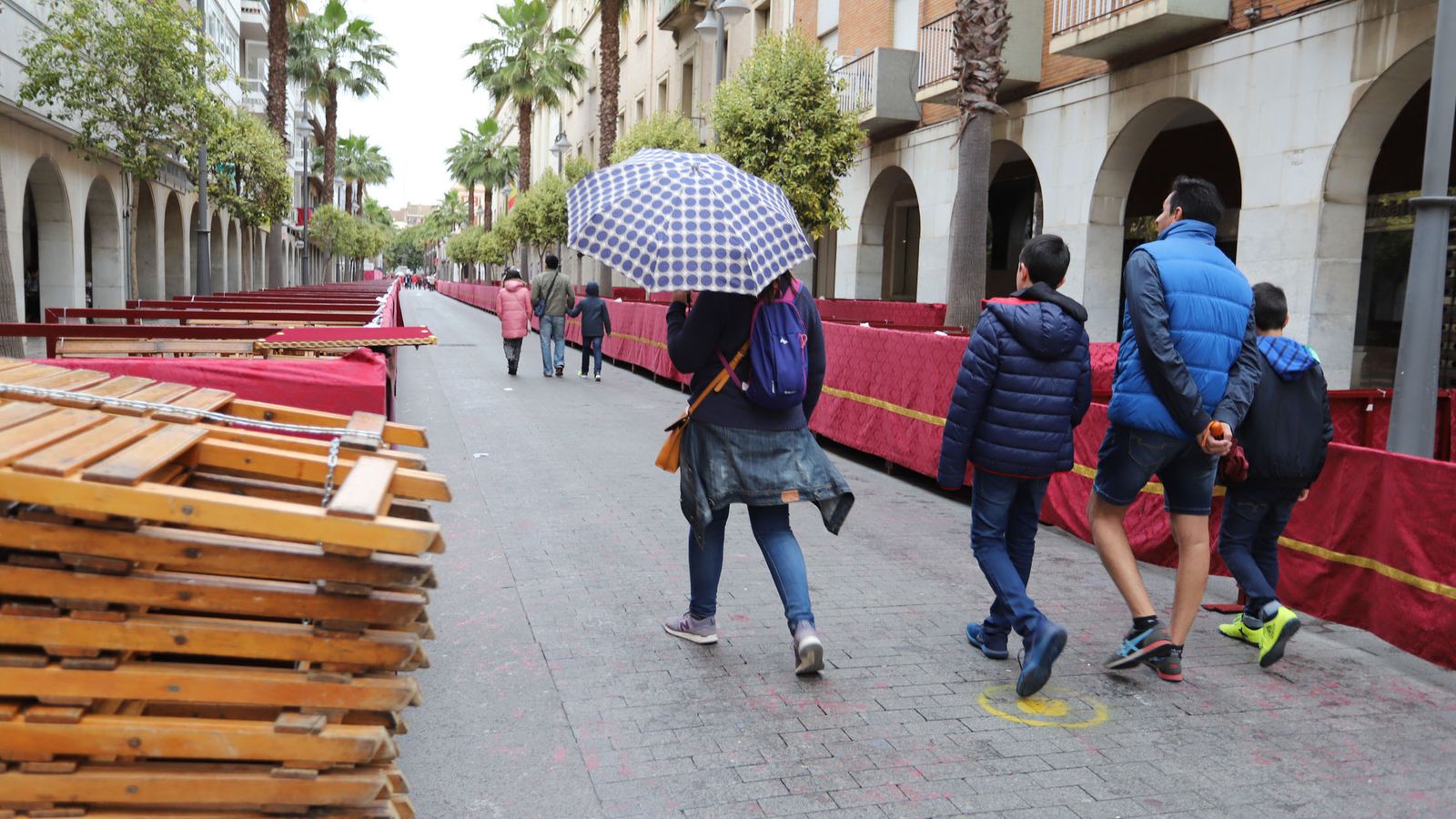 Varias personas caminan por la Carrera Oficial de Huelva.
