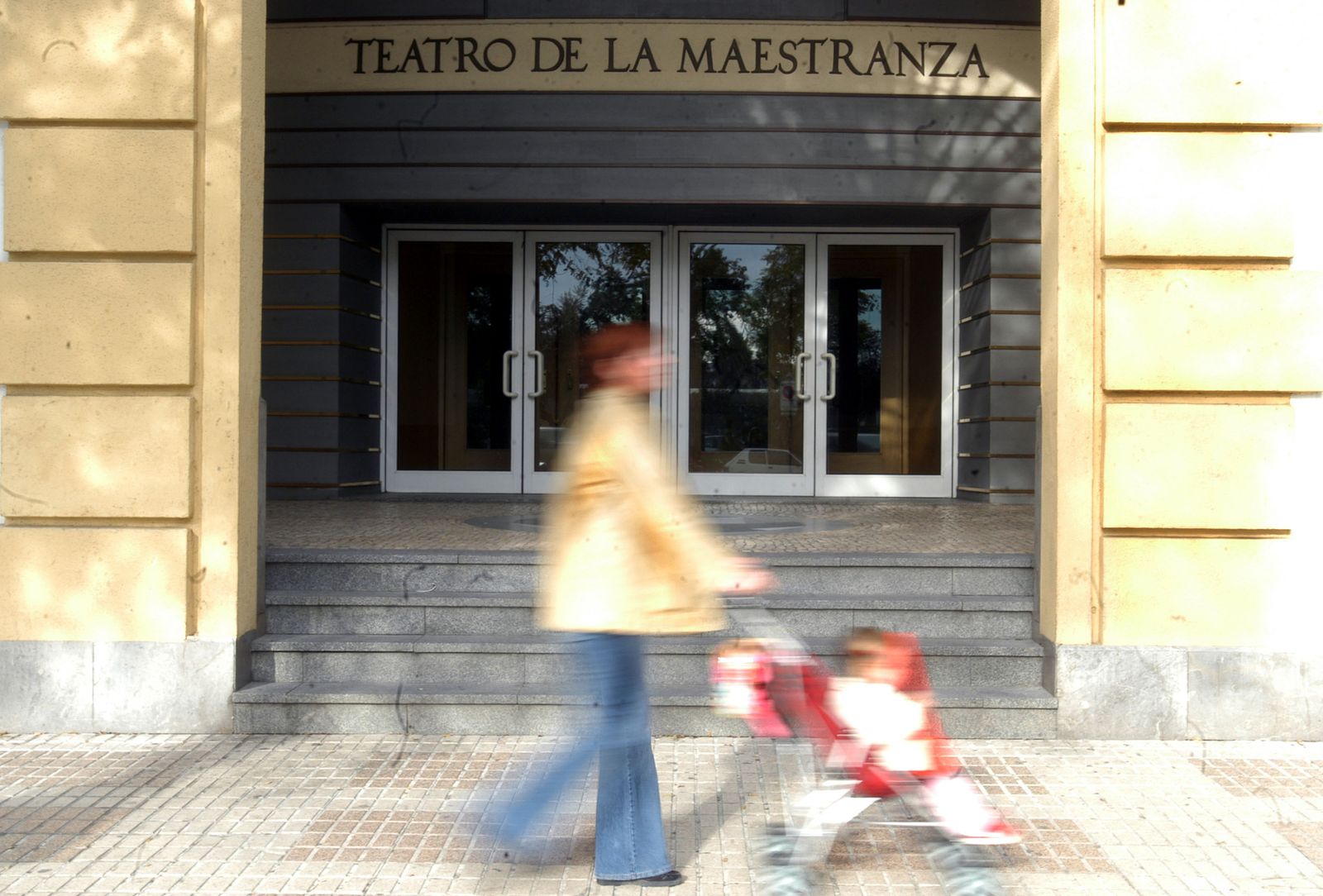 Una mujer pasa por la puerta del Maestranza.