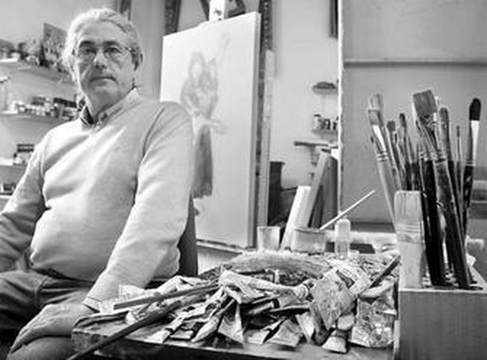 Basto en su estudio posando ante uno de sus cuadros.