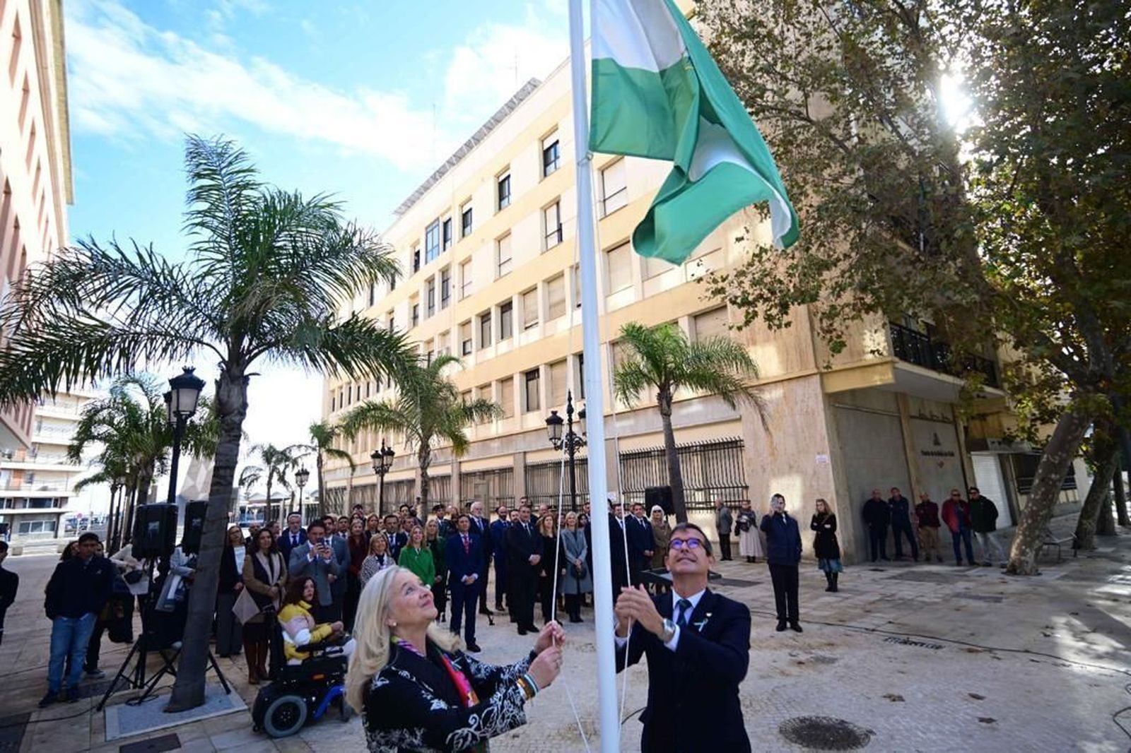 Mercedes Colombo y Jorge Paradelas izan la bandera de Andalucía en el acto de este domingo.