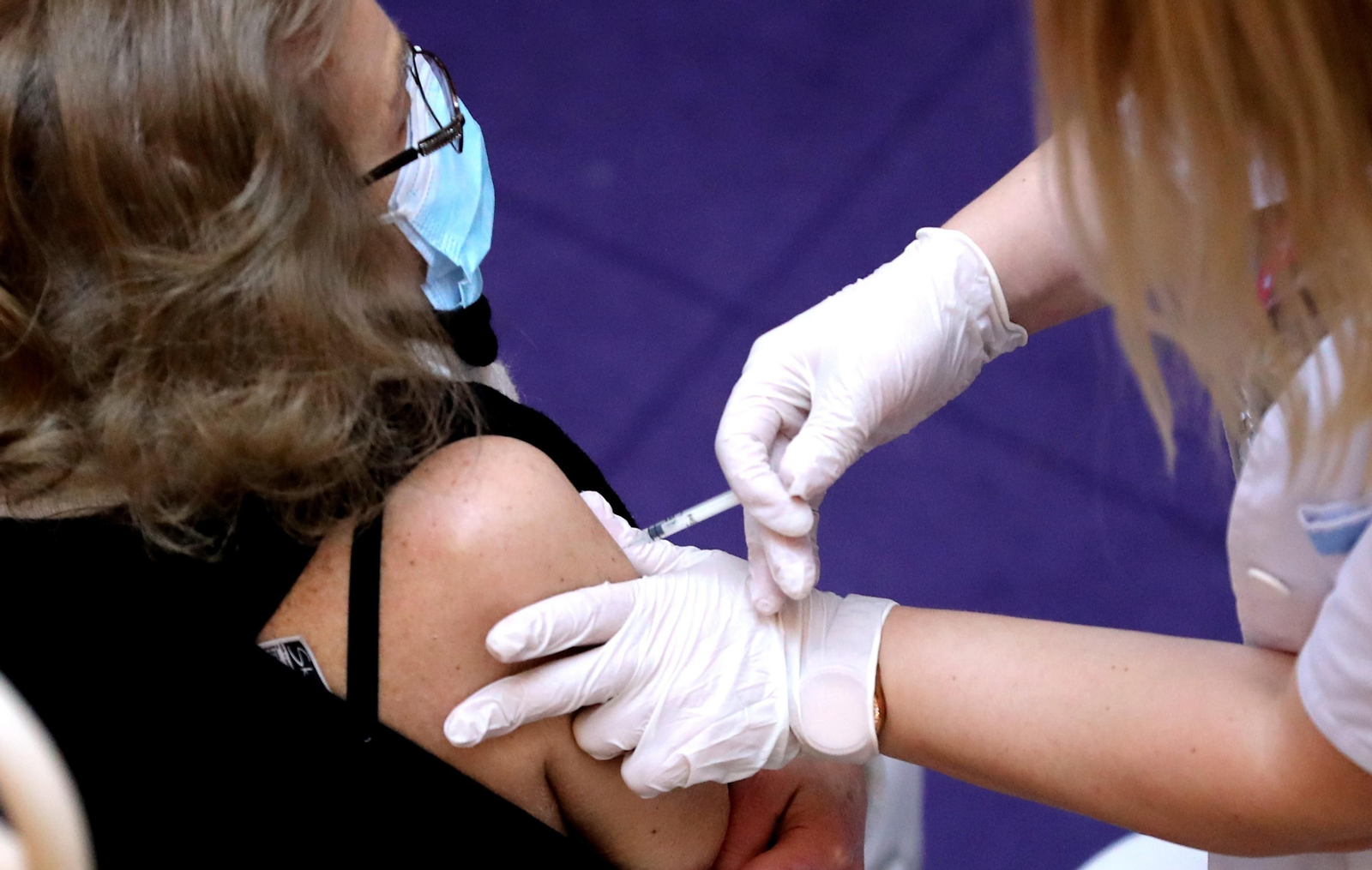 Una mujer poniéndose una vacuna.