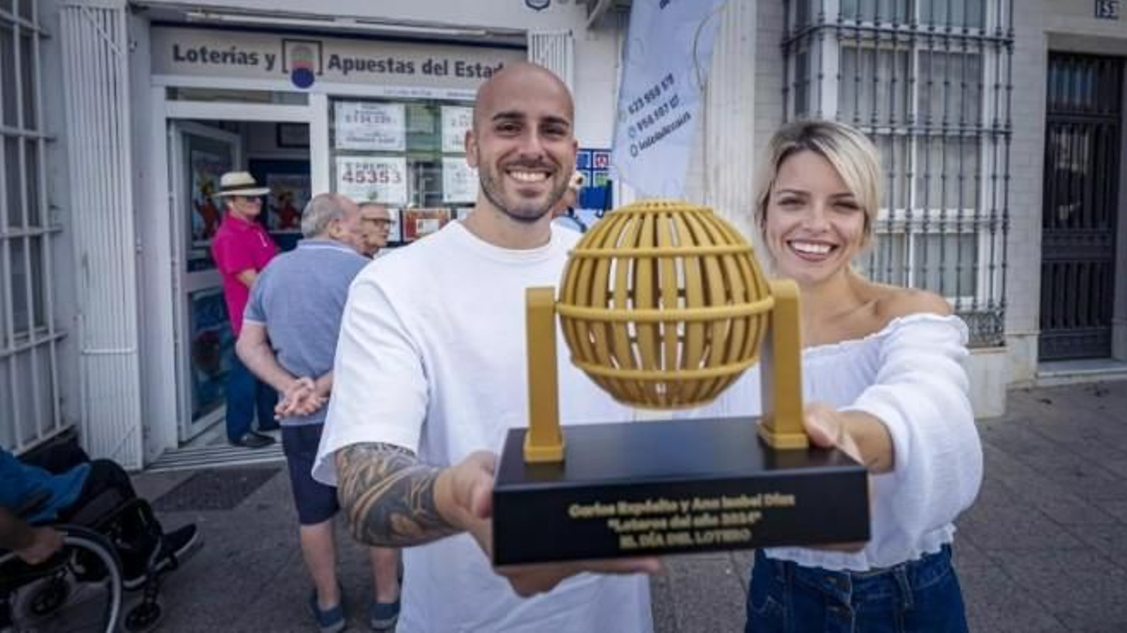 Los responsables de ‘La Lola de Cai’, con el galardón que les reconoce como loteros del año 2024.