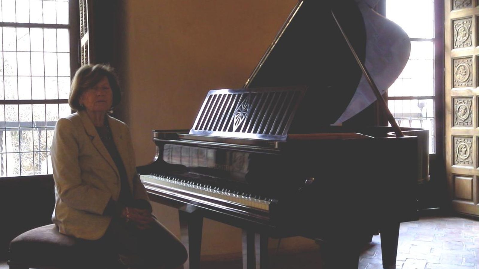 Carmen Alonso, hija del compositor, e la exposición con el piano de 1929 con el que componía Francisco Alonso