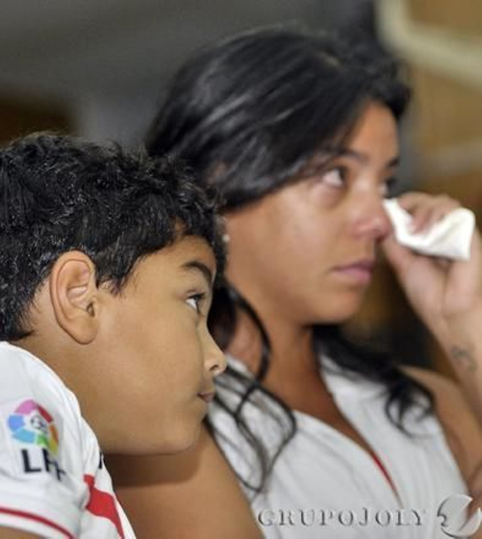 La mujer del futbolista se seca las lágrimas en el acto de despedida del Sevilla de su marido.

Foto: Manuel Gómez