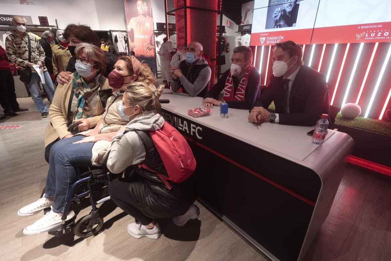 Una enferma de ELA posa ante Unzué, Monchi y Lopetegui durante la firma de libros.