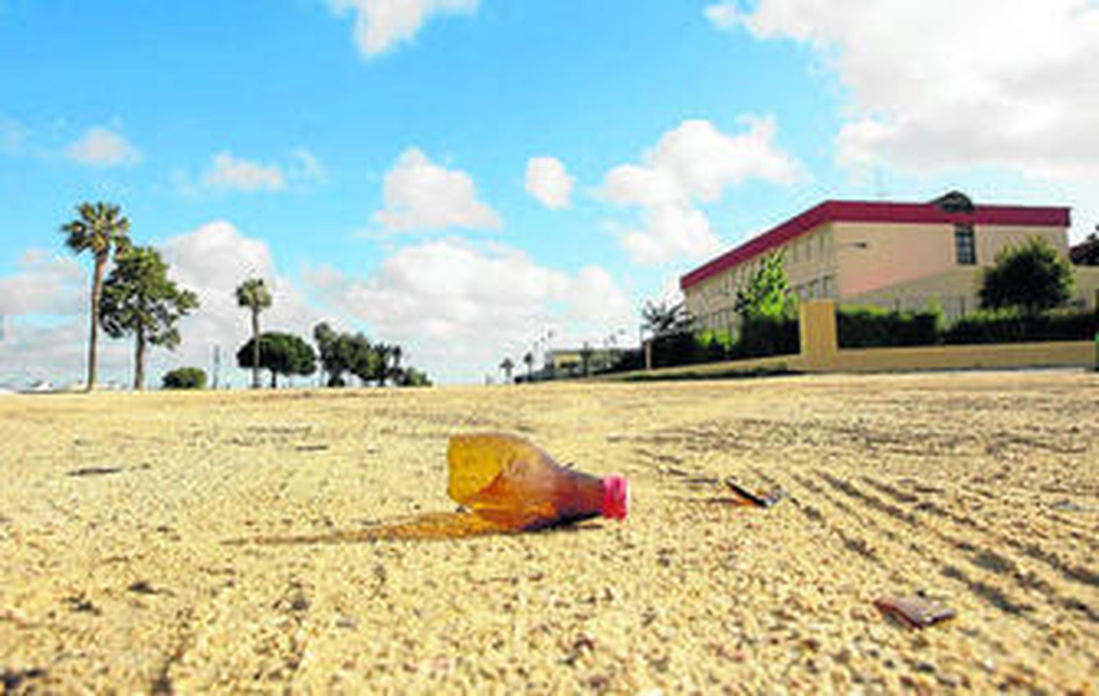 Botellas rotas y otros restos en la zona de La Magdalena más próxima al IES Sancti Petri.