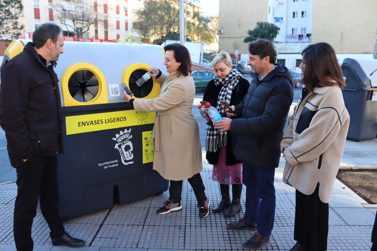 Varios concejales depositan botellas de plástico en un contenedor. Varios concejales depositan botellas de plástico en un contenedor.