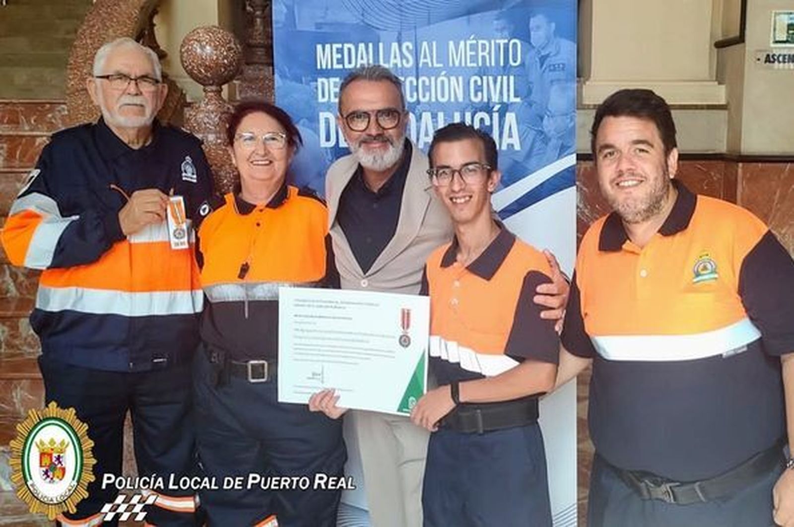 Voluntarios de Protección Civil Puerto Real tras recoger la distinción