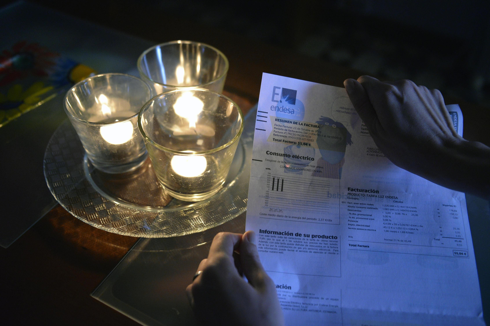 Una factura de la luz, junto a unas velas encendidas. Una factura de la luz, junto a unas velas encendidas.