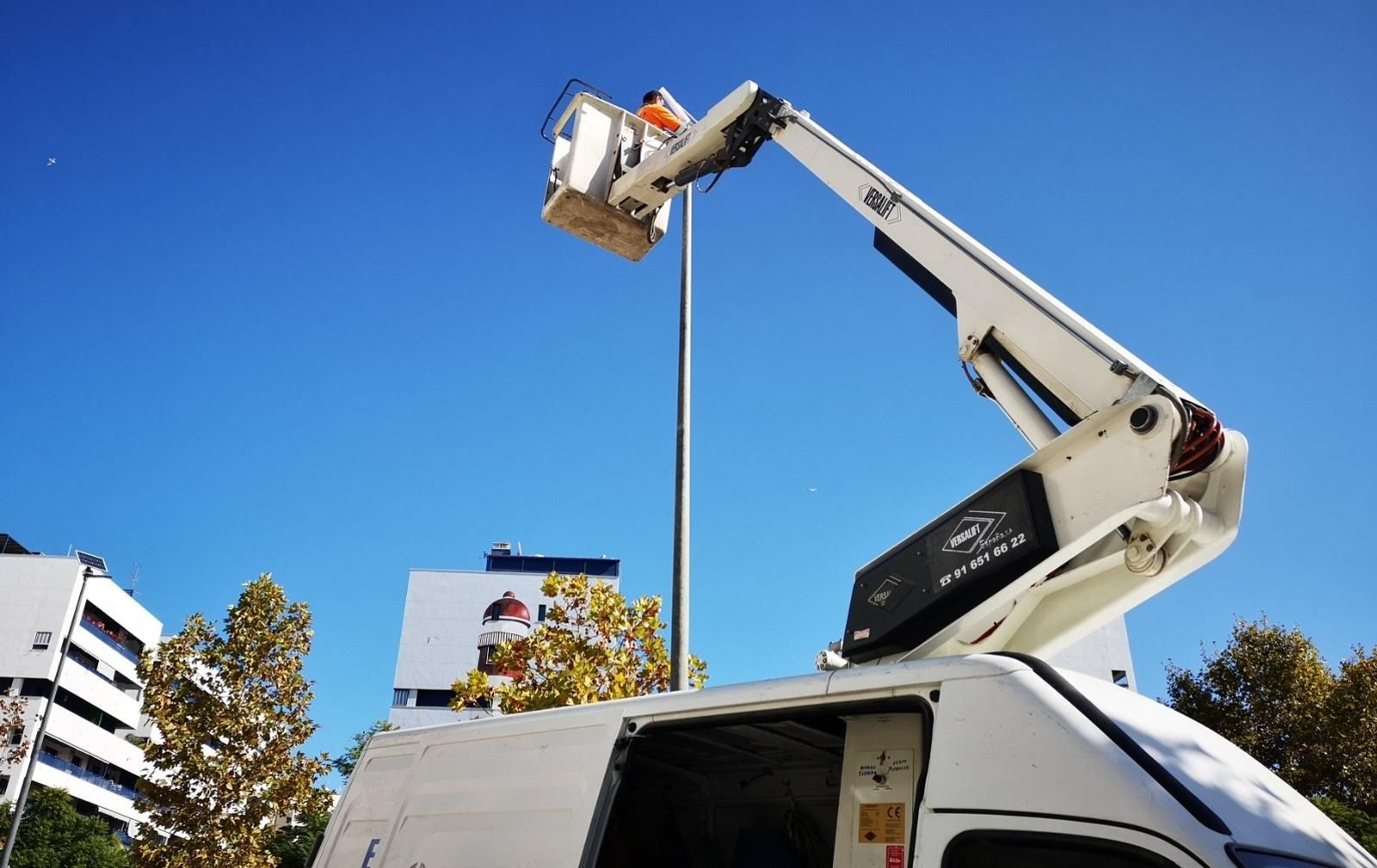 Un operario instalando una farola. Un operario instalando una farola.