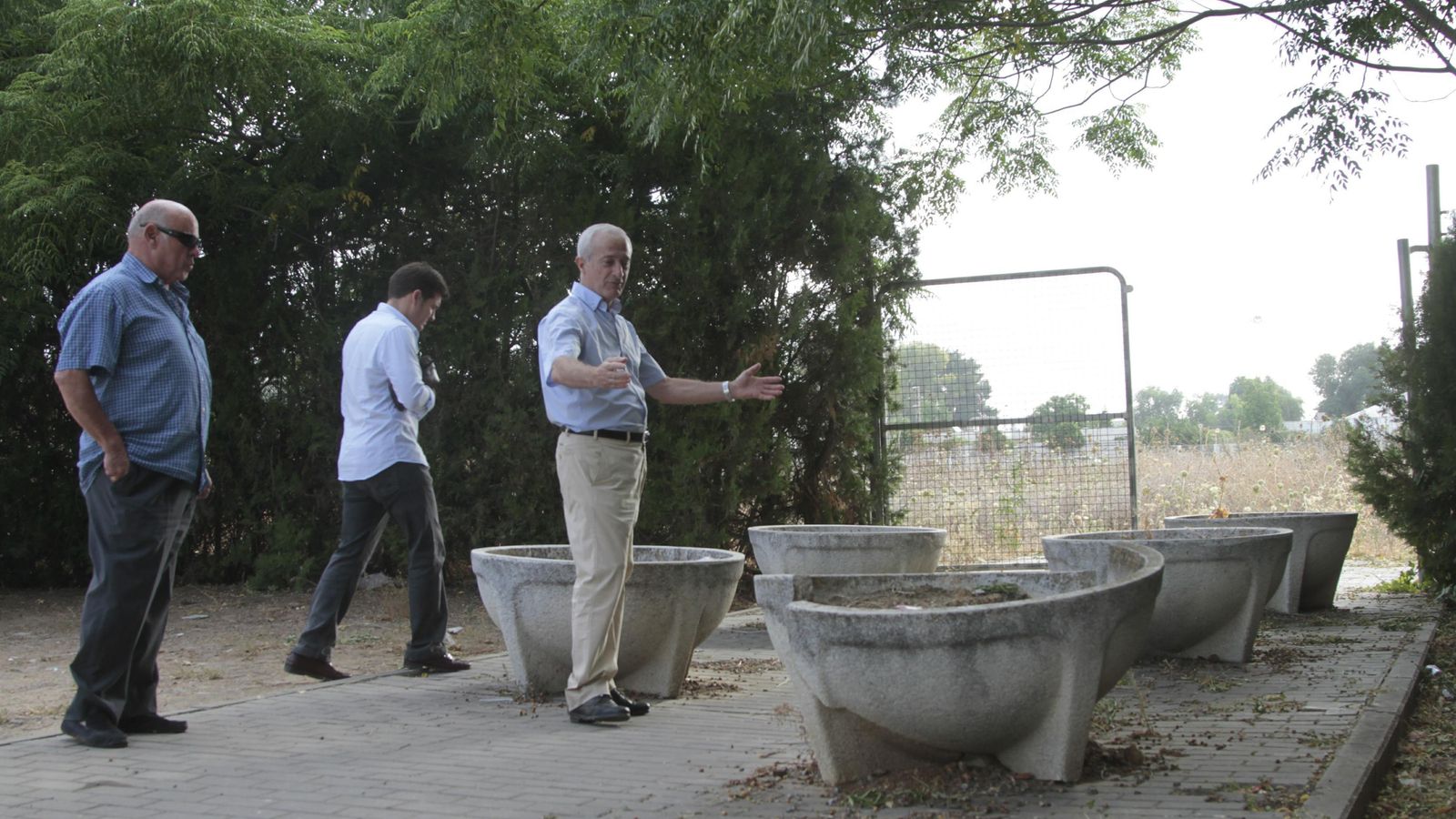 Enrique Dorronzoro señala los macetones de piedra colocados en el acceso peatonal del ambulatorio, junto a un solar lleno de malezas.