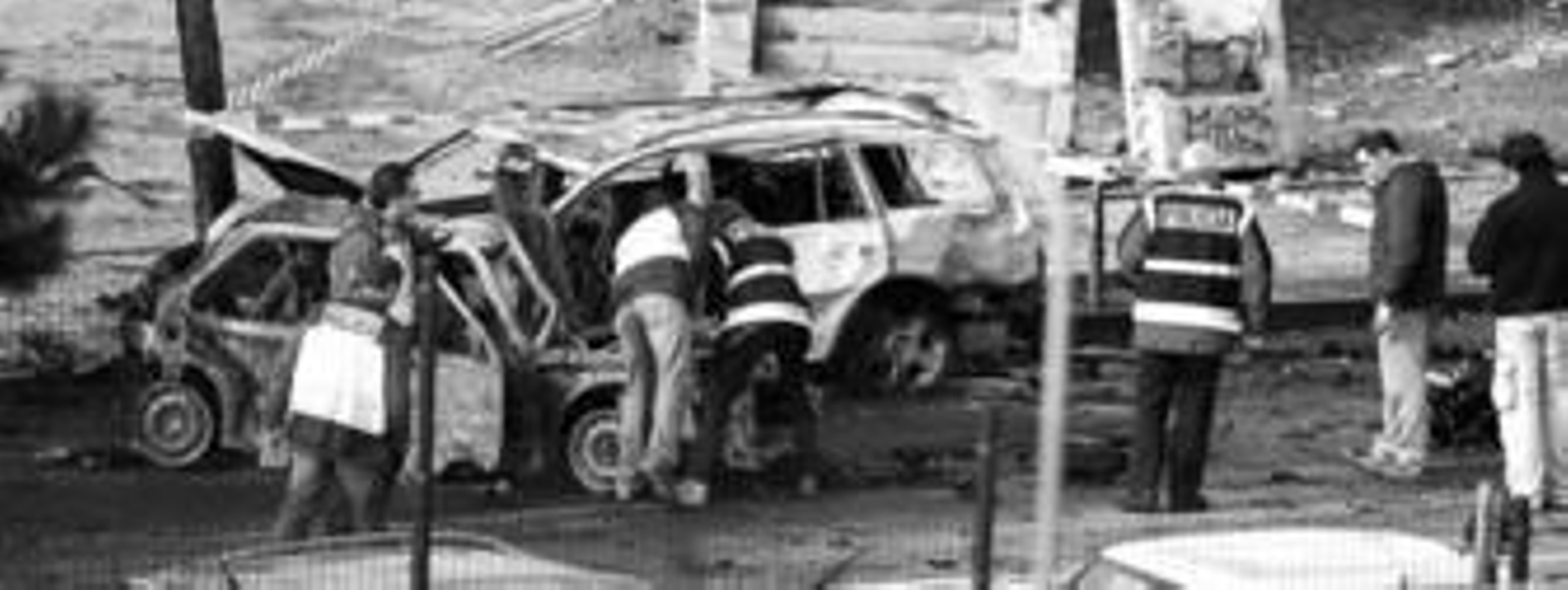 Miembros de la Policía científica examinan los restos de la furgoneta utilizada por ETA en busca de huellas que puedan facilitar la identidad de los autores.