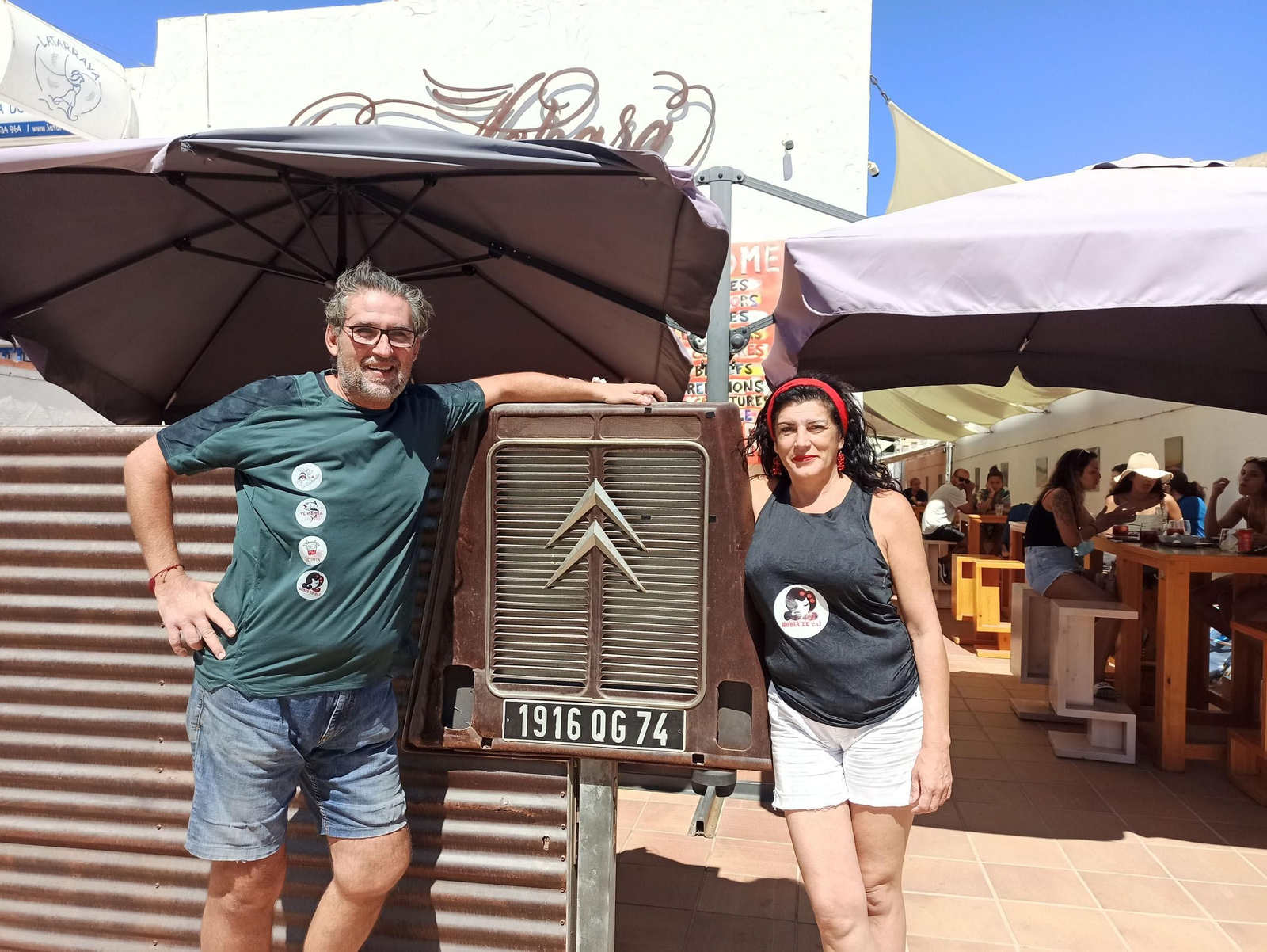 Miguel Ángel y Oliva, frente a la puerta del local, el frontal de una antigua furgoneta Citroen.