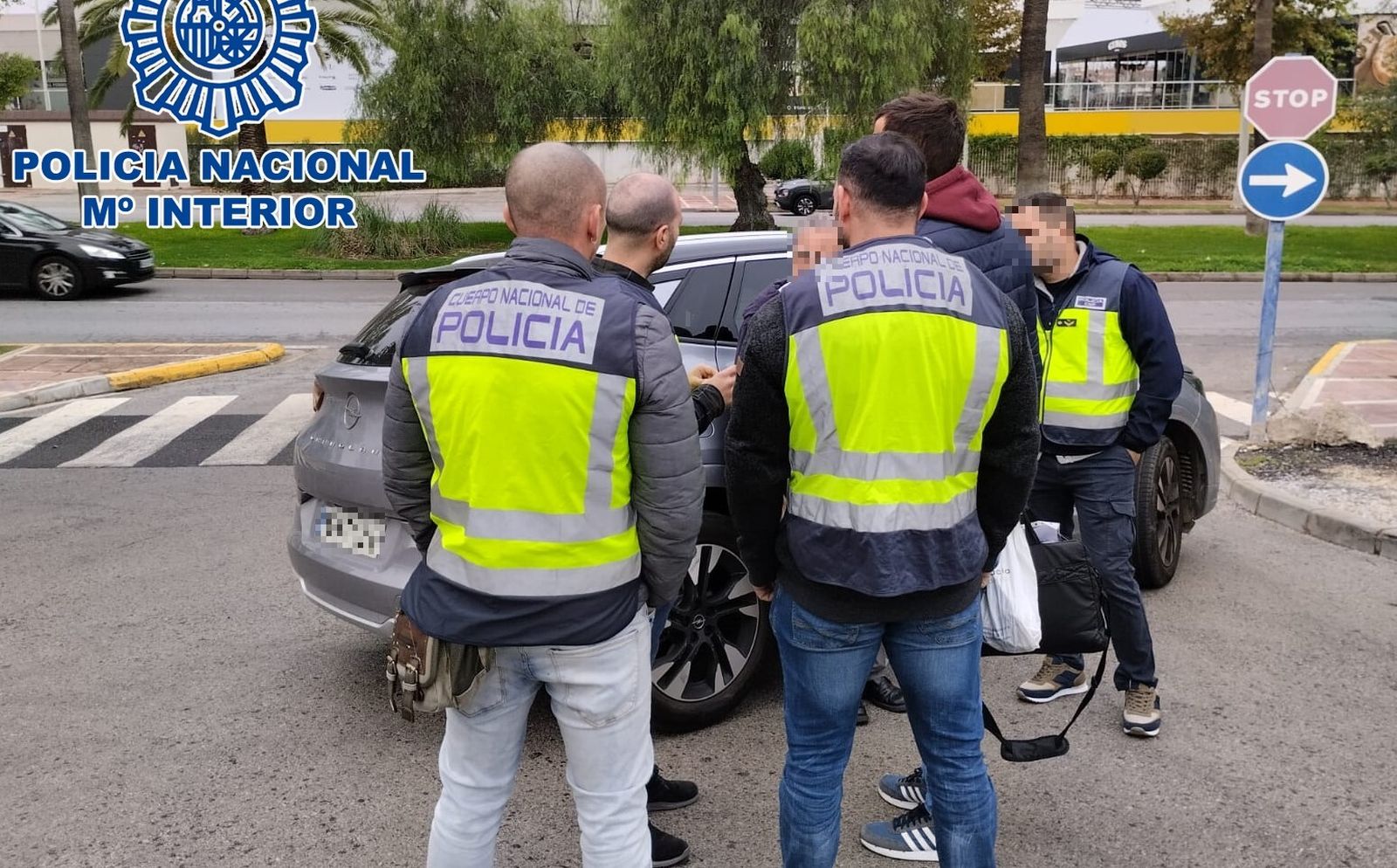 Varios agentes de la Policía Nacional rodean al presunto estafador en el momento de su detención.