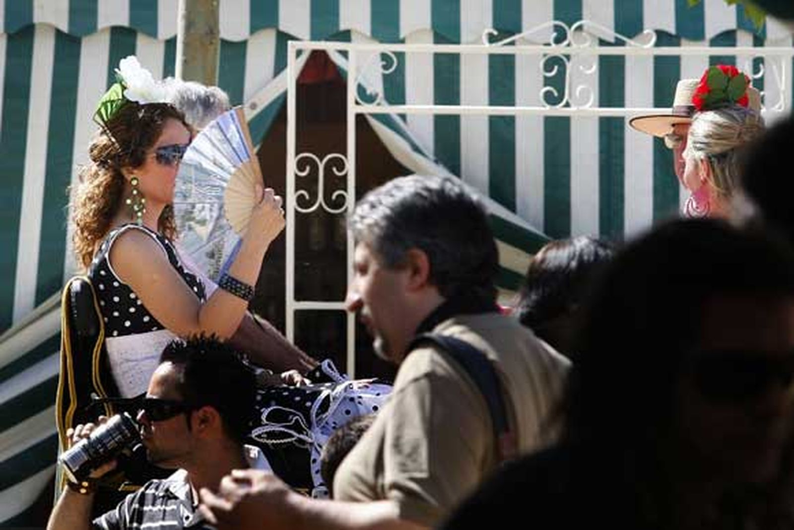 Una joven vestida de flamenca se abanica mientras pasea en un coche de caballos./Fotos:Fito Carreto

Foto: Fito Carreto