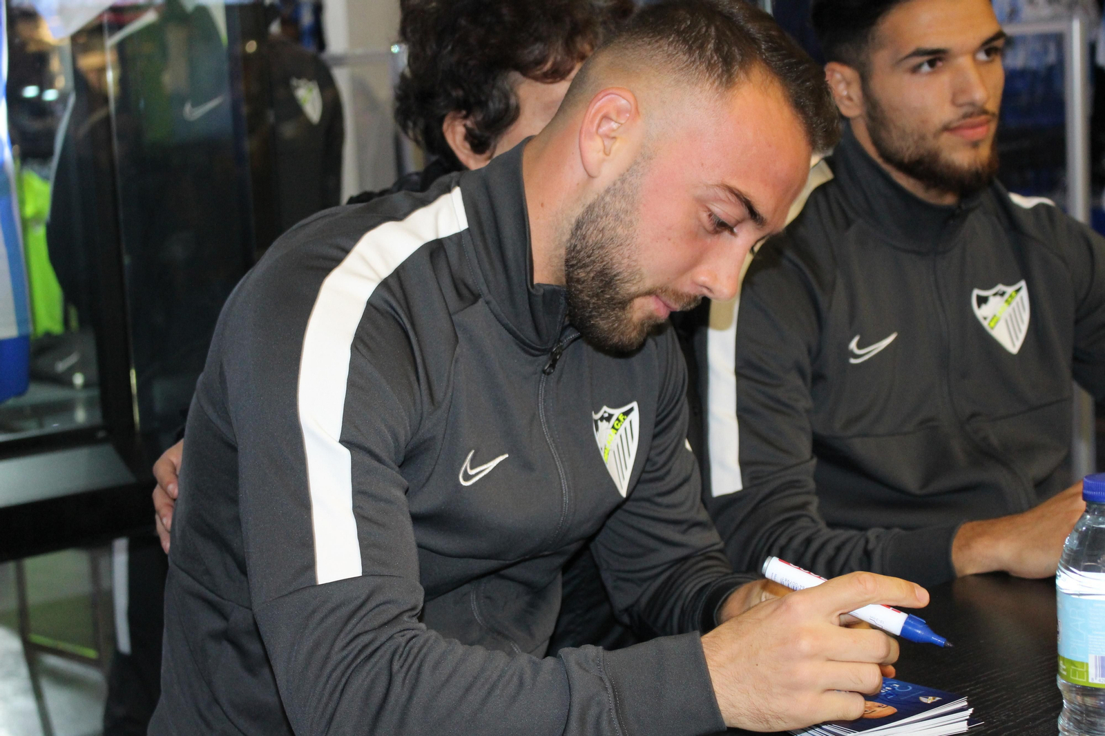 Antoñín y Keidi Bare se hacen fotos y firman a los aficionados del Málaga CF