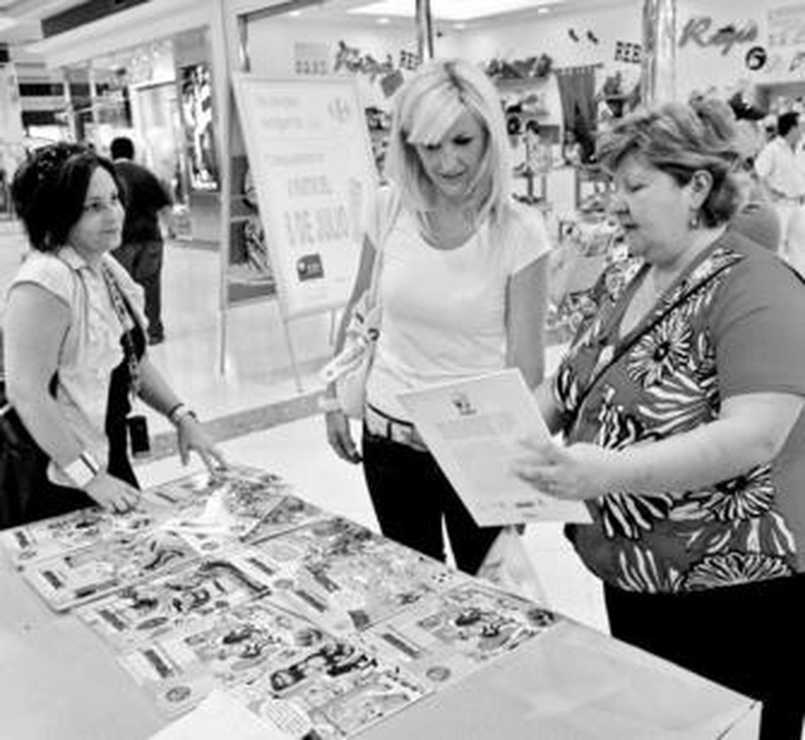 Mari Carmen Herencia muestra a una mujer uno de los cómics de Mortadelo y Filemón