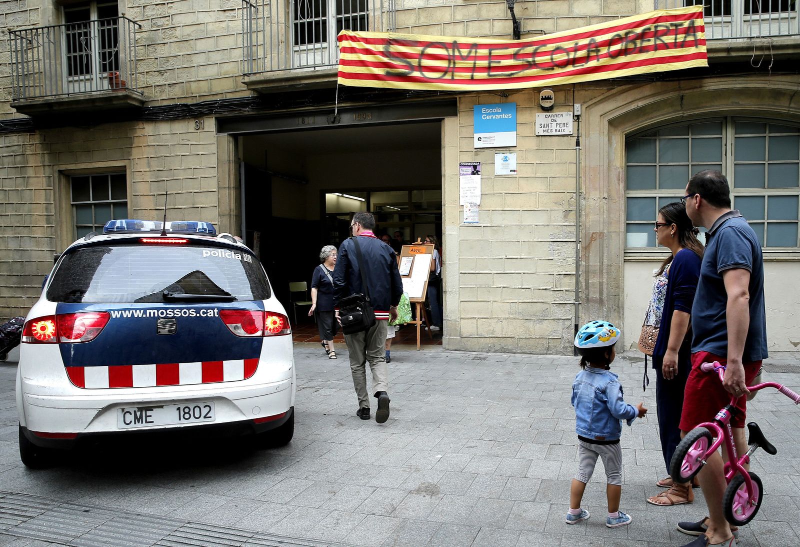 Un vehículo de los Mossos d'Esquadra ante uno de los colegios ocupados en Barcelona.