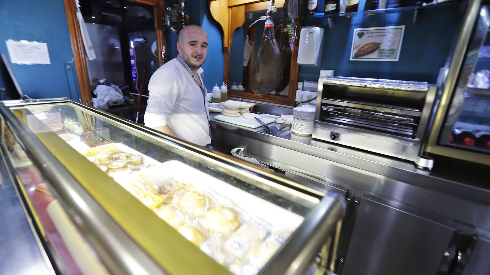 Adrián, tras la barra del bar y salón de juegos Plus Ultra de la capital onubense.