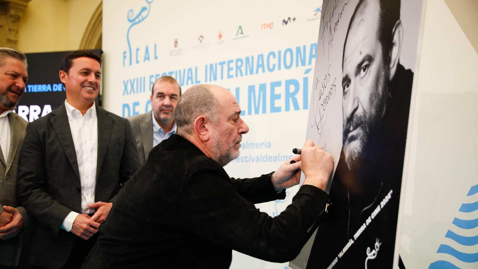 Karra Elejalde firmando en su fotografía en presencia de Javier A. García.