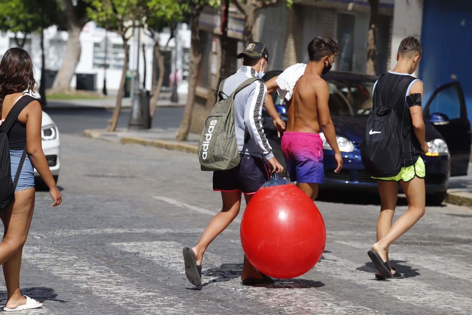 Un grupo de jóvenes pasea por Huelva con sus mascarillas.