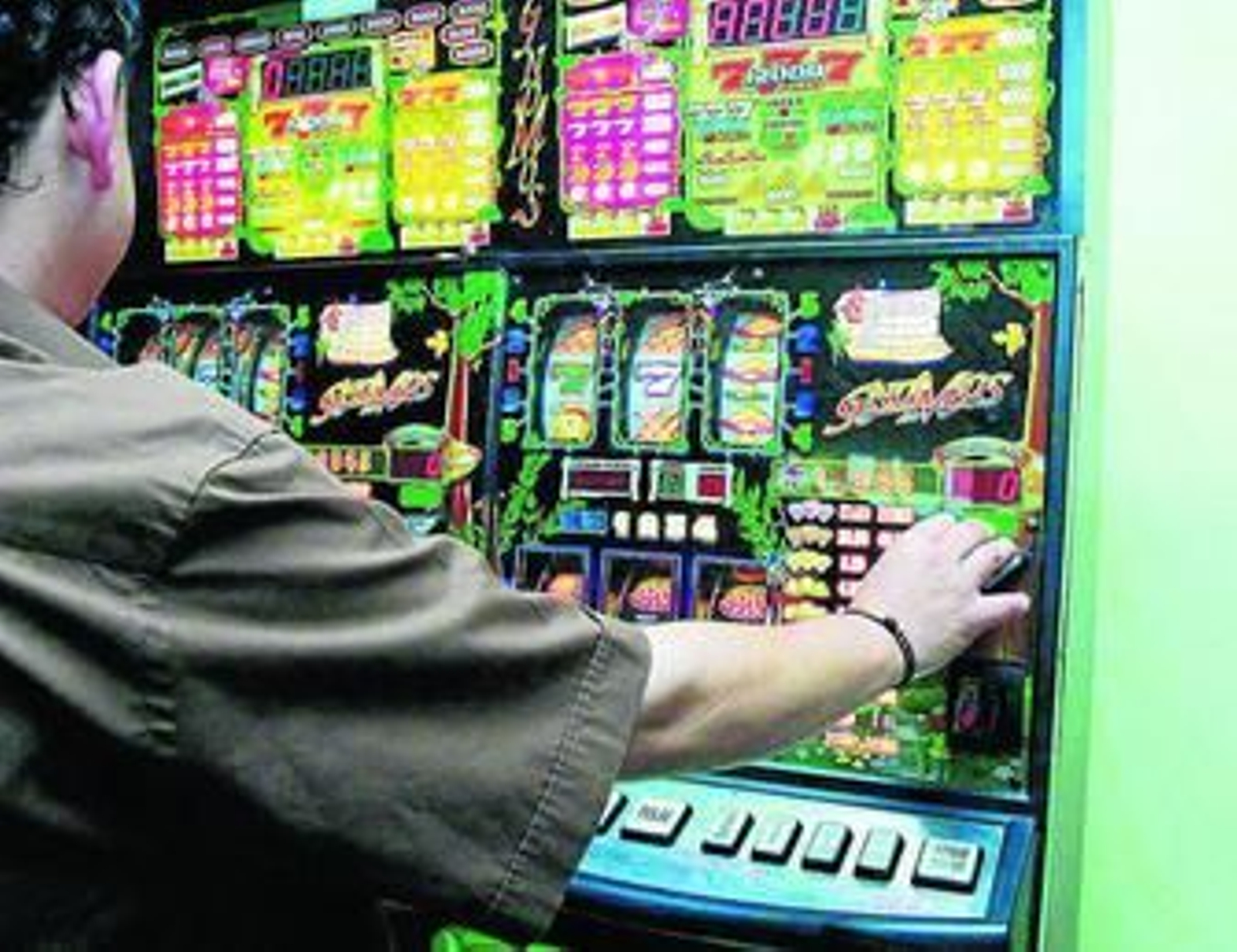 Un hombre juega en una máquina tragaperras.