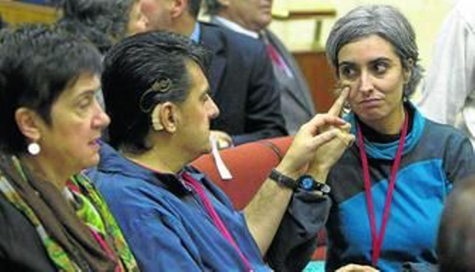 Dos personas hacen uso de la lengua de signos en la tribuna del Parlamento andaluz en la aprobación de la ley que regula su uso.