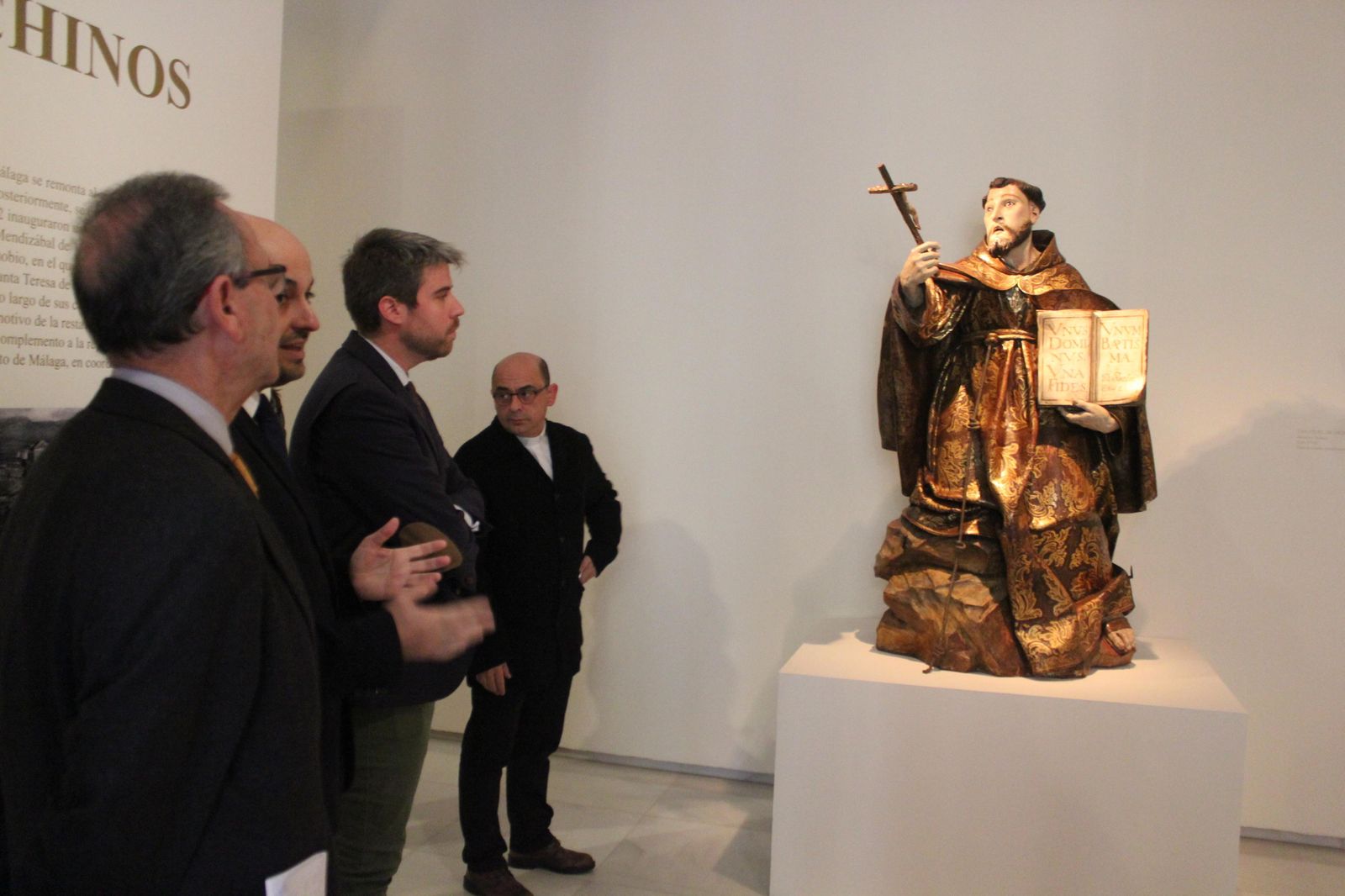 El periodista Jesús Hinojosa explica a los responsables de la Fundación Málaga y el Obispado una de las obras de la muestra.