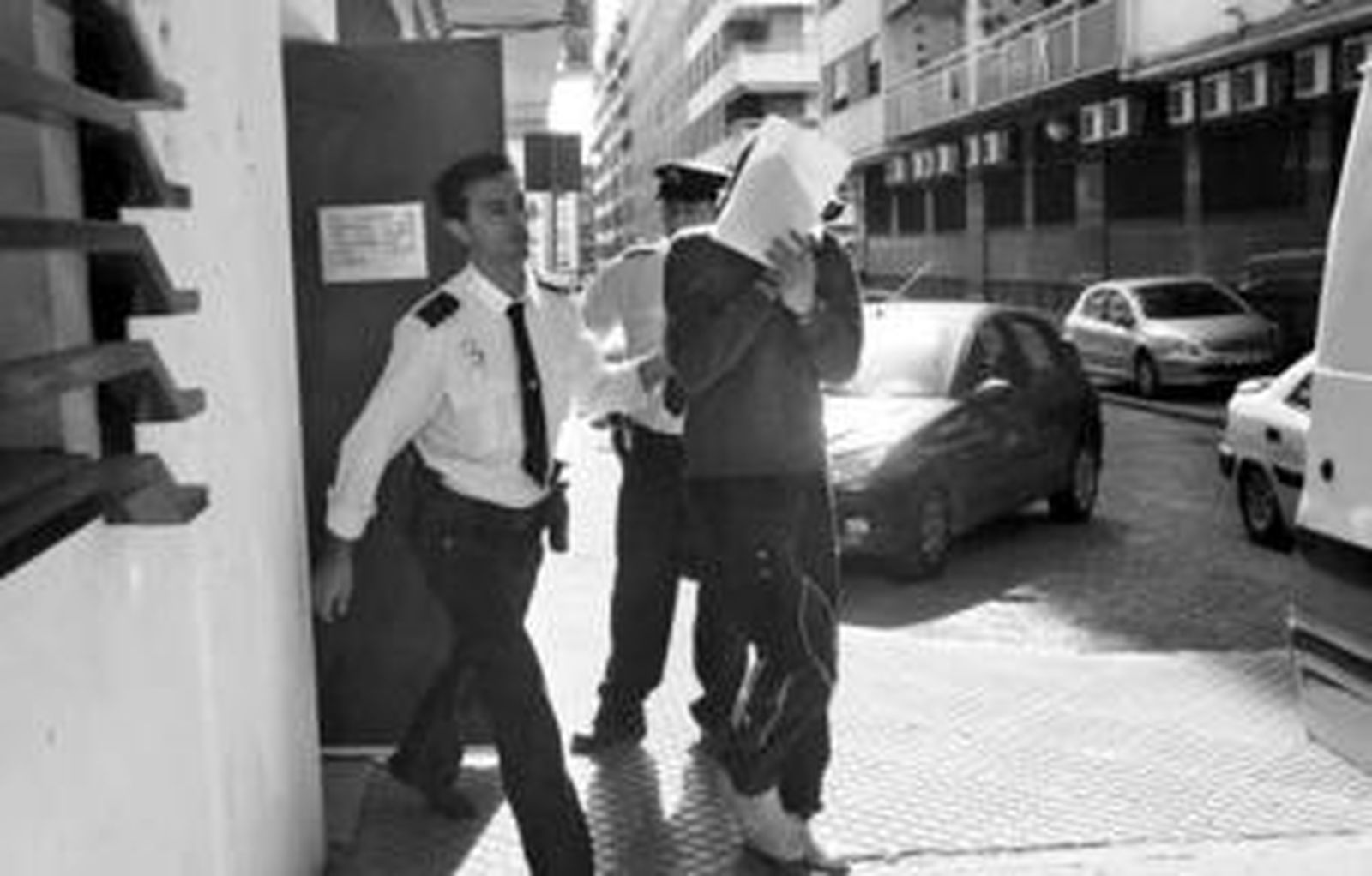Unos agentes dirigen a uno de los jóvenes arrestados tras prestar declaración.