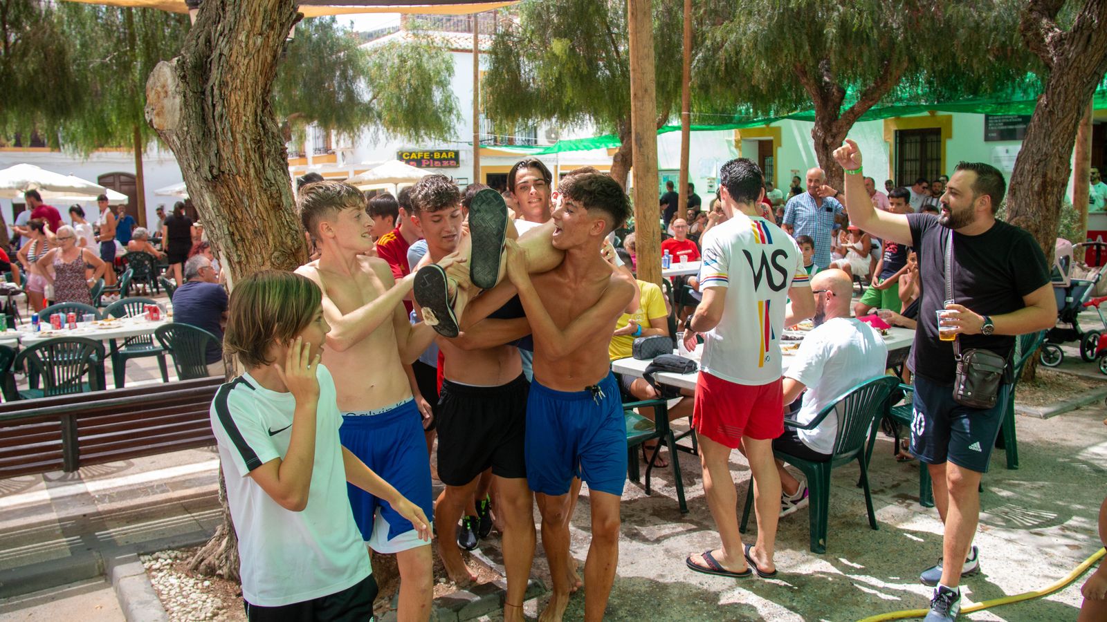 Un grupo de jóvenes trasladando a un vecino hasta la fuente