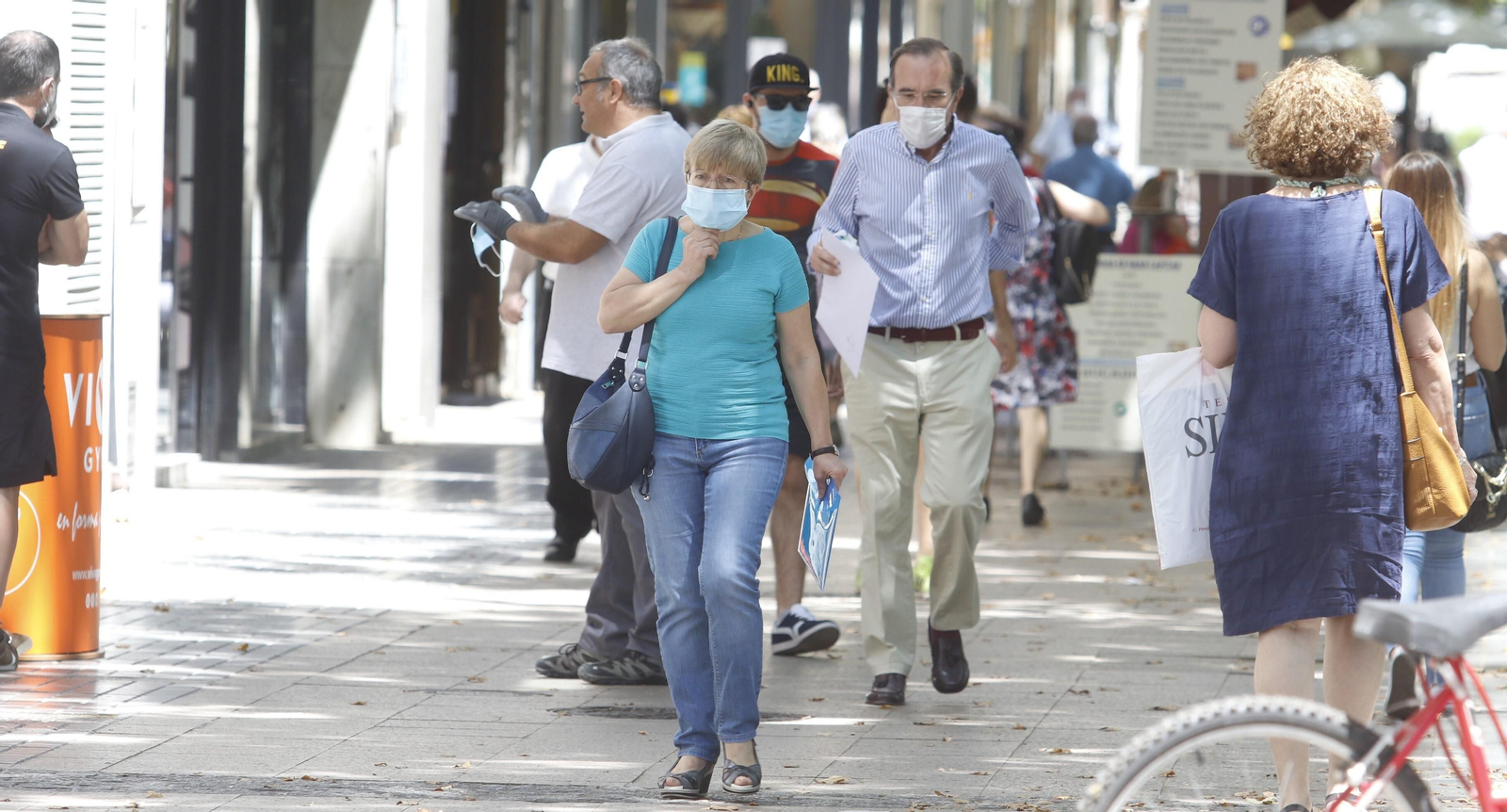 Viandantes caminan por el centro de Córdoba ataviados con mascarilla.