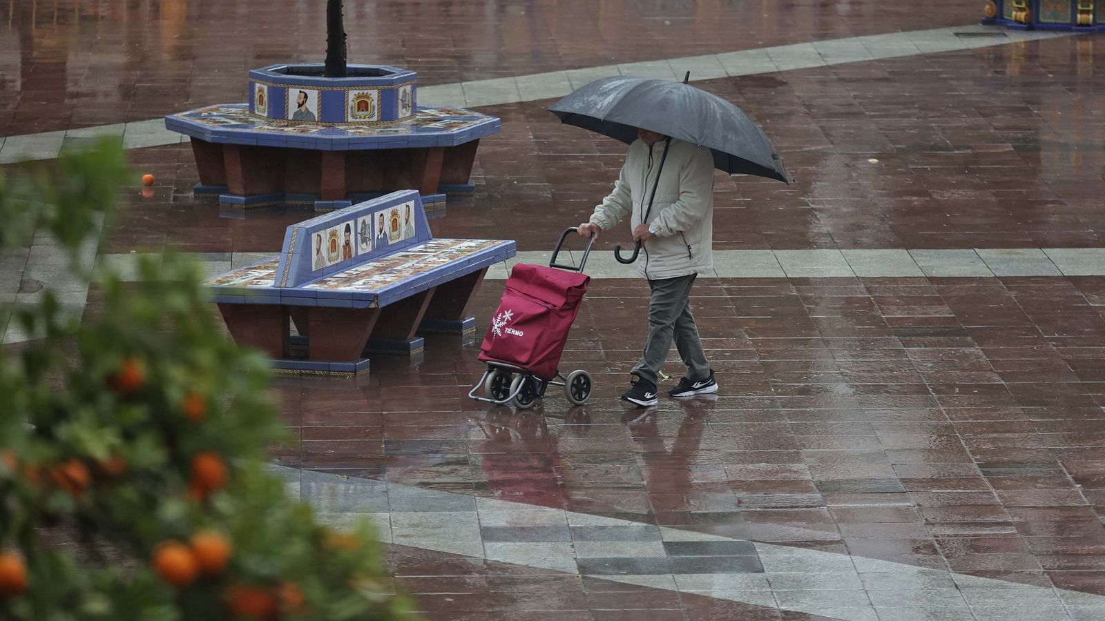 Un vecino con un carrito de la compra en mitad de la borrasca Leonardo en Algeciras.