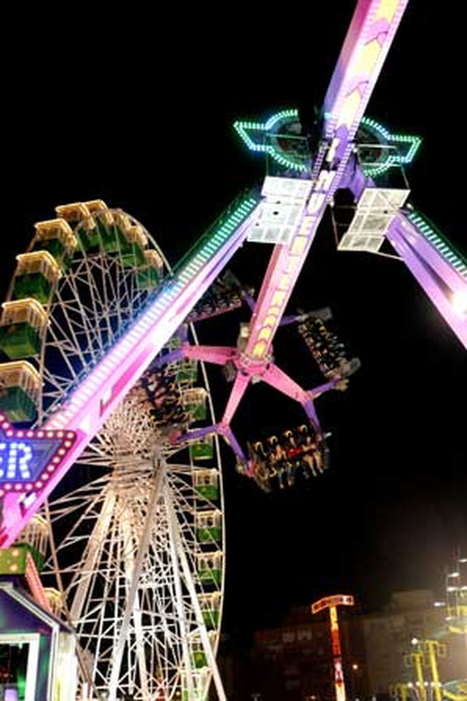 Imagen de la noria a la izquierda junto a otra de las grandes atracciones de la feria

Foto: Vanessa Perez/J.M.Q.