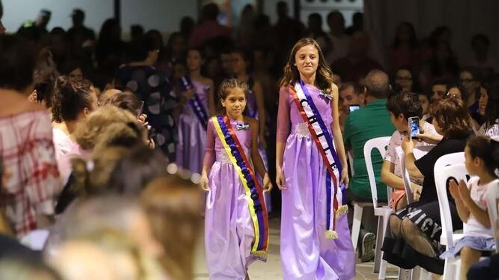 Niñas que representan a países iberoamericanos en un acto de coronación de la reina de las fiestas.