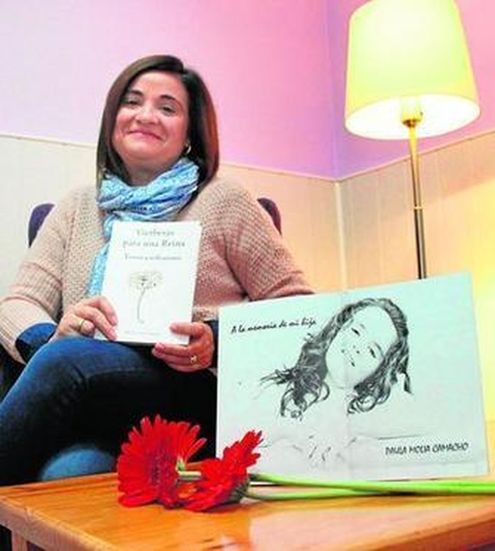 Mónica Camacho posa con un ejemplar del libro, que incluye una fotografía de su hija Paula, junto a unas gerberas.