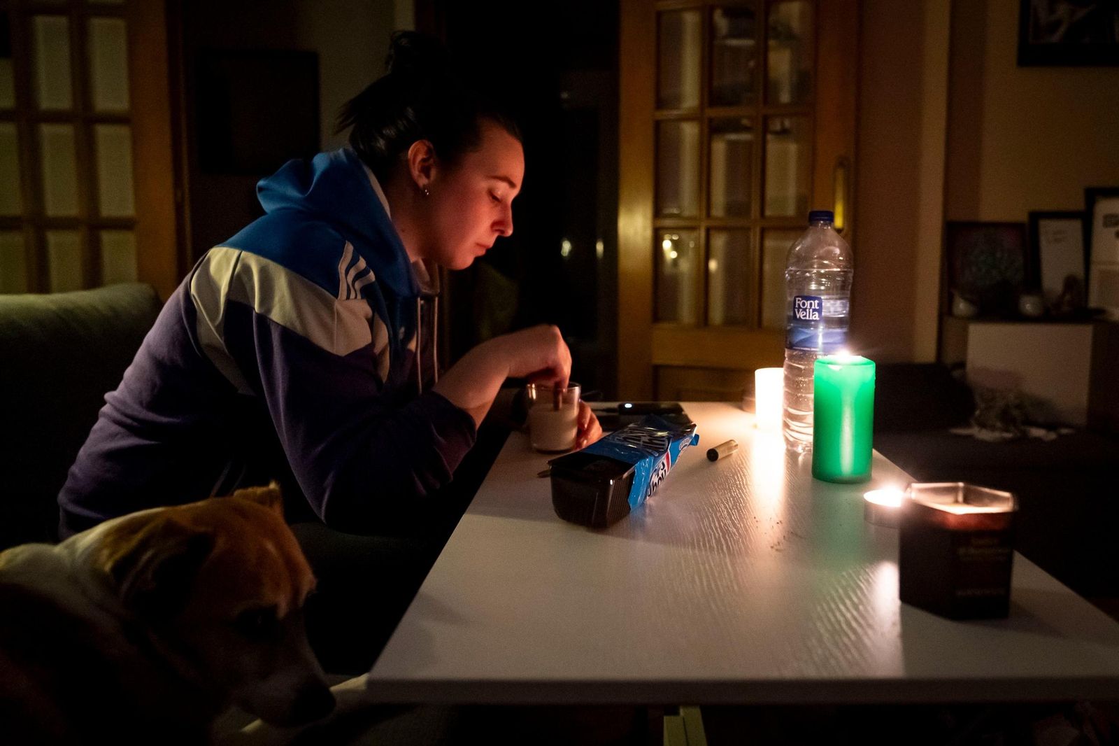 Una joven merienda pensativa a la luz de las velas, el lunes del apagón en España.