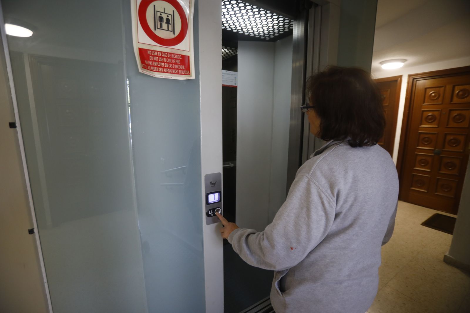 Una mujer se sube al ascensor de su bloque de pisos en Córdoba.
