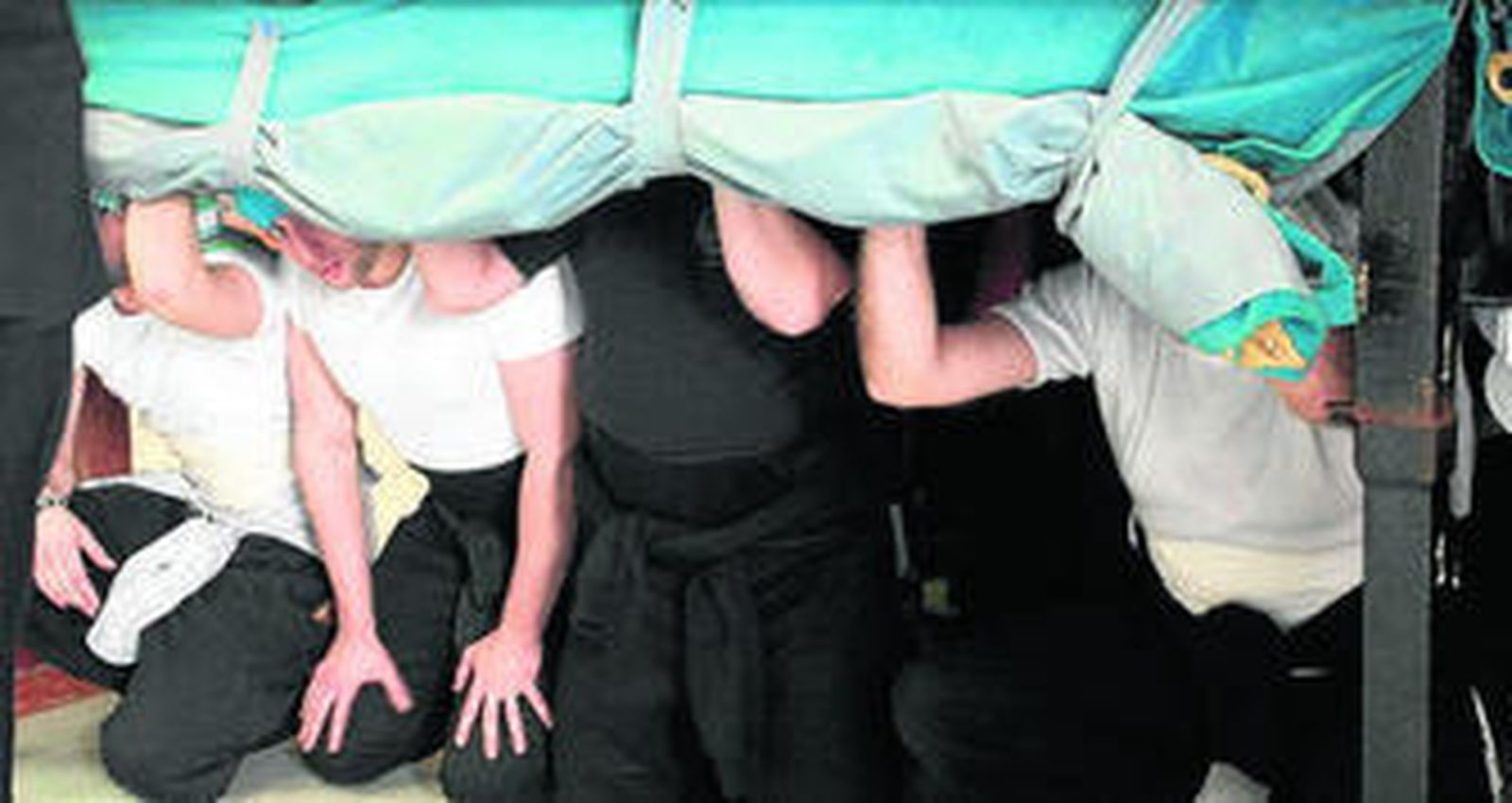 Los costaleros, de rodillas, esperando la salida.