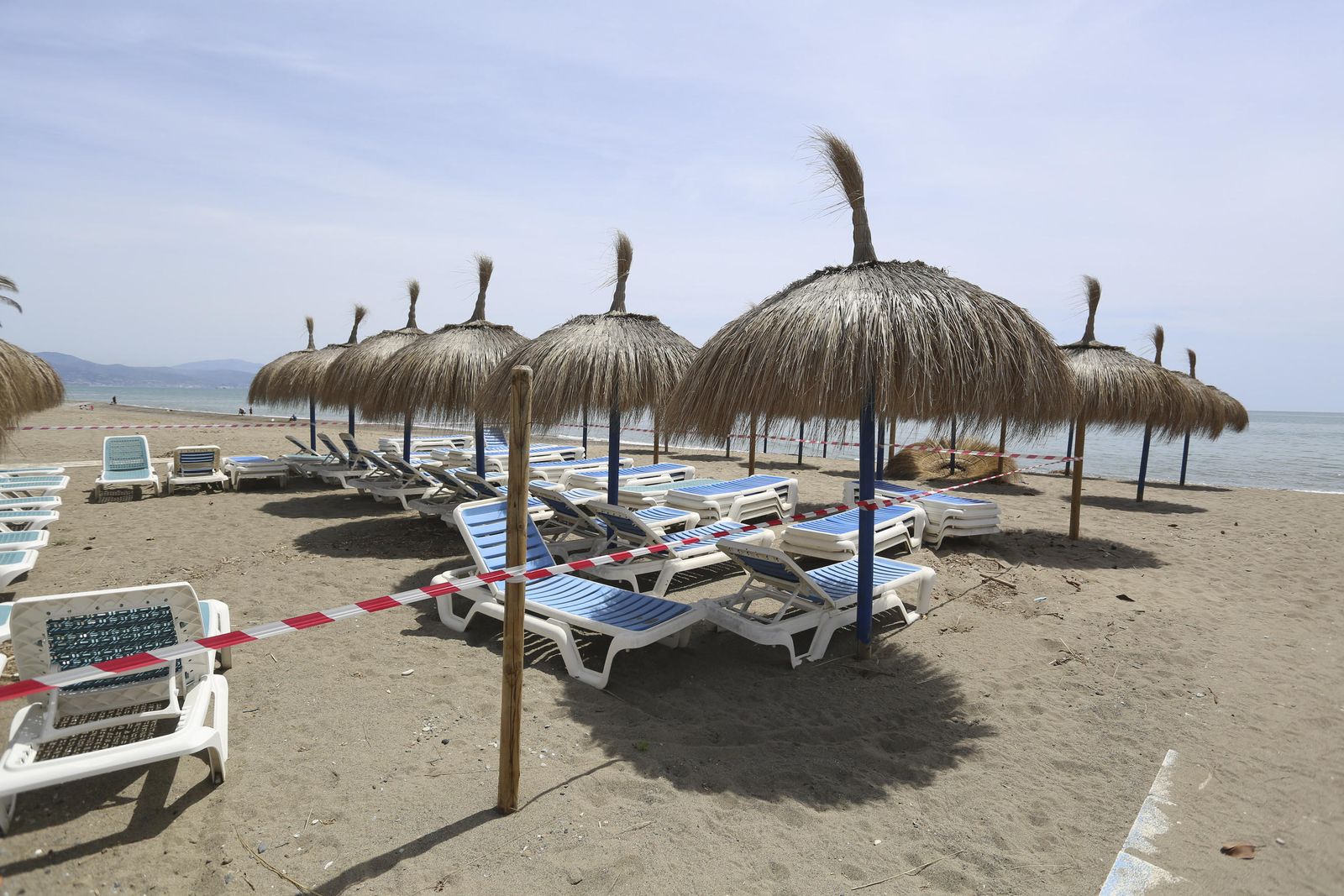 Varias hamacas precintadas en la playa en Málaga.
