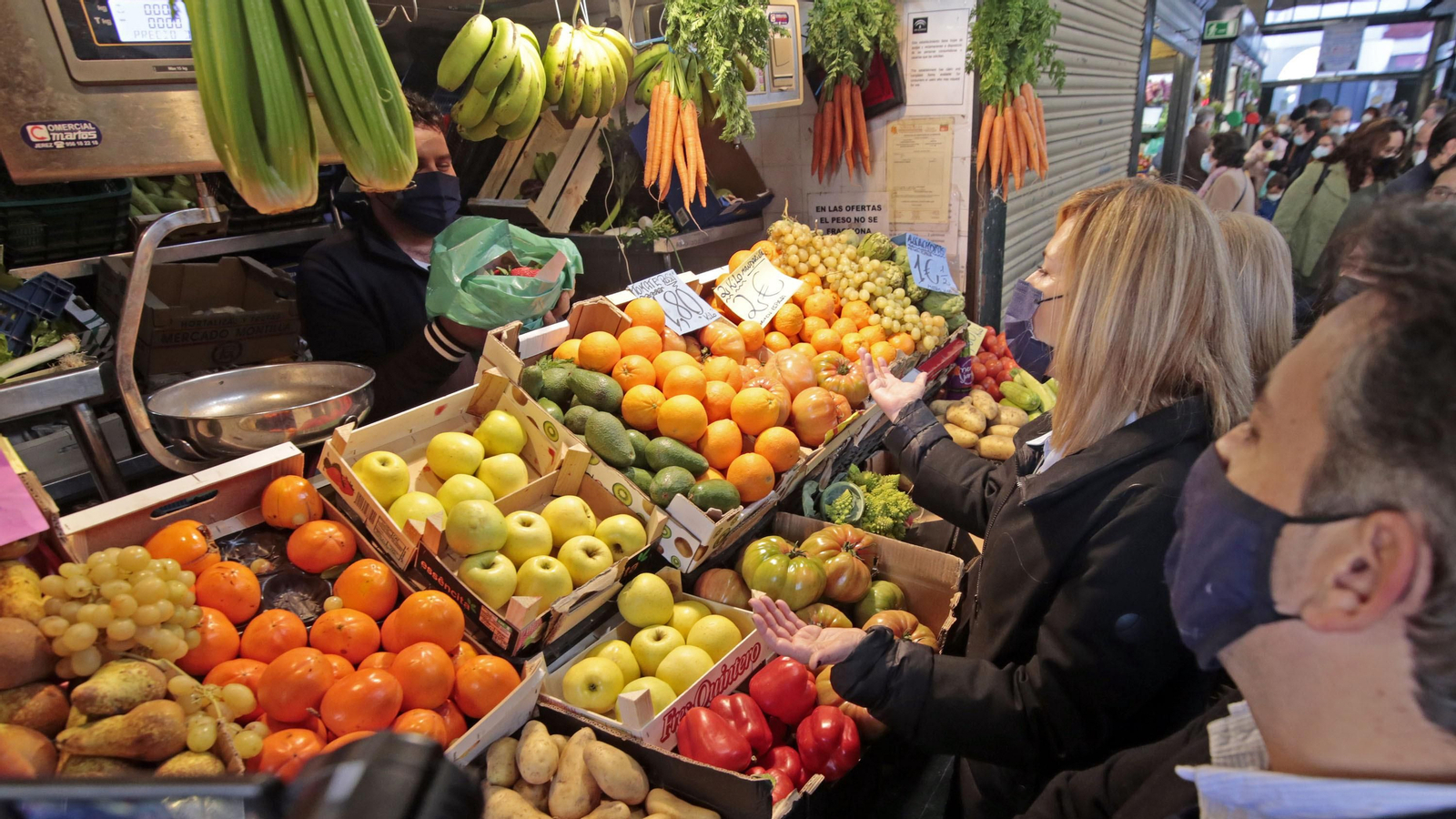 Una mujer compra fruta en una plaza de abastos.