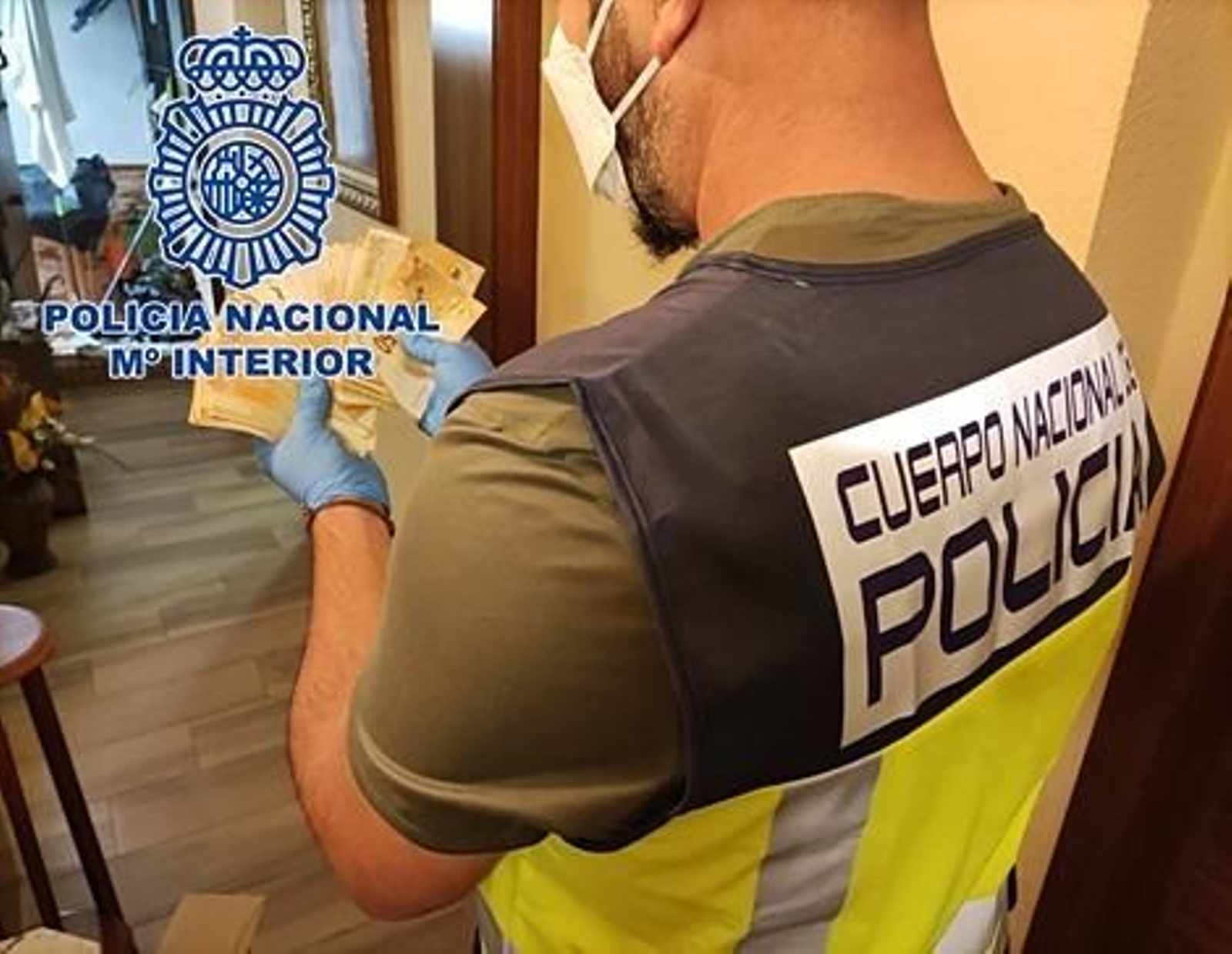 Un policía nacional muestra los billetes falsos intervenidos.