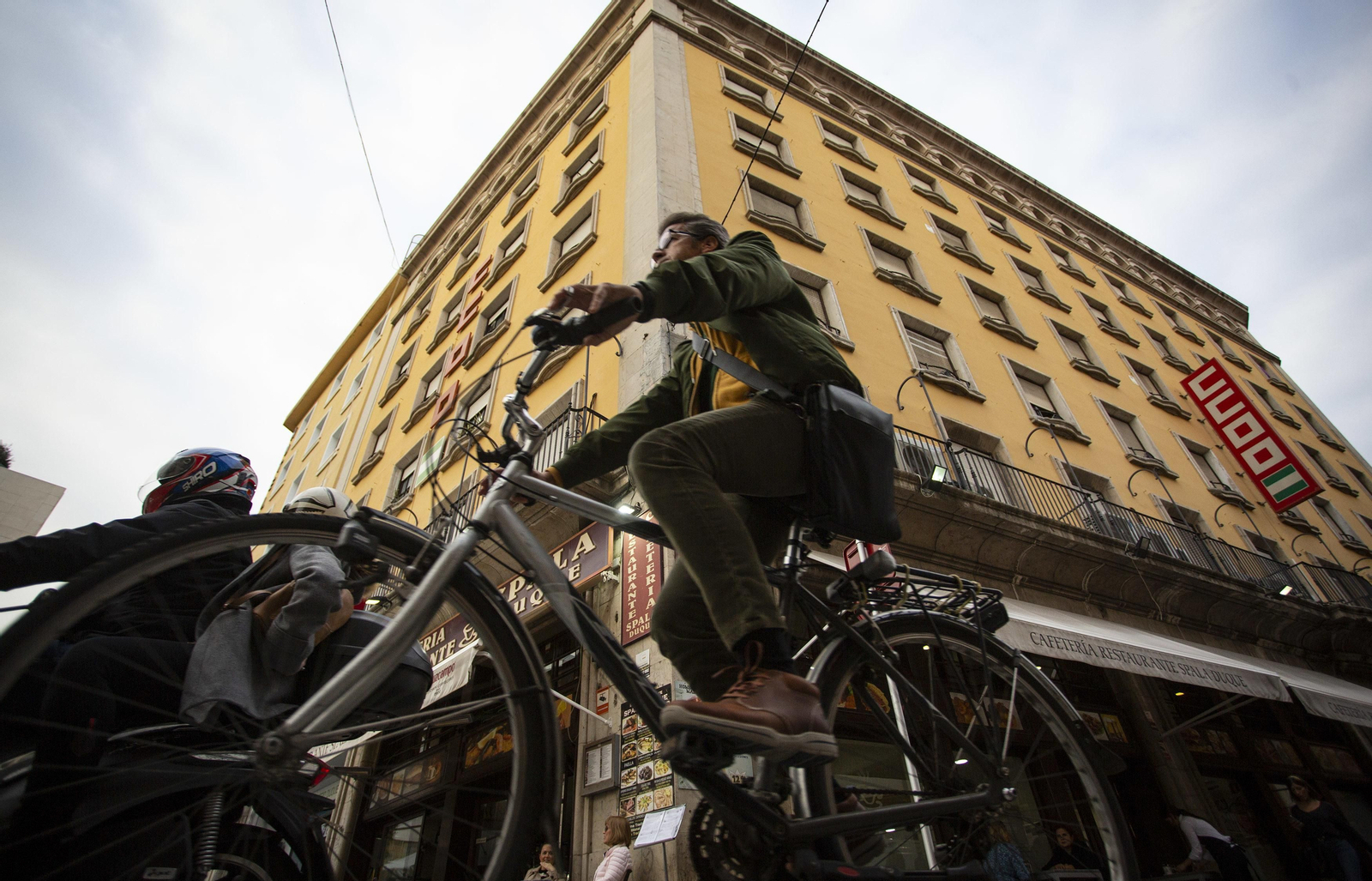 Un ciclista pasa junto a la fachada del edificio de Comisiones Obreras, esquina de la Plaza del Duque con la calle Trajano.