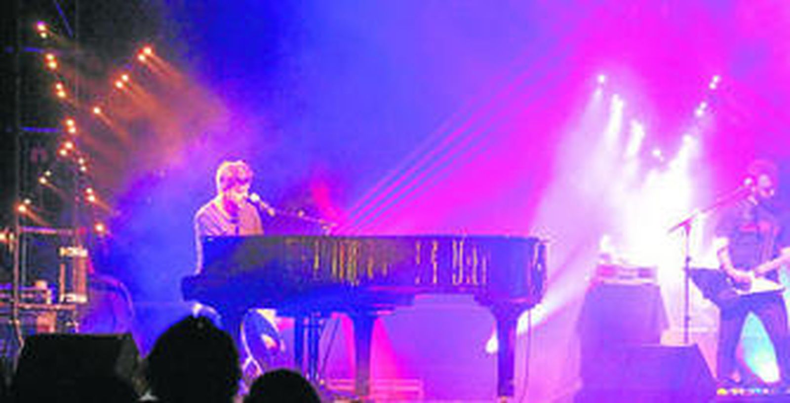 El cantante malagueño tocando el piano mientras las luces juegan a su alrededor durante el concierto ayer en el parque María Cristina.