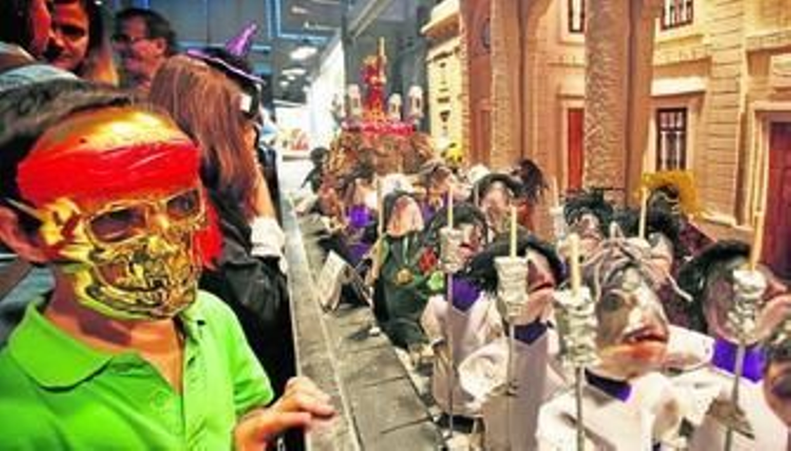 Un niño con careta observa el expositor de la pescadería de Juan de Micaela, que estaba dedicado a los 400 años del Nazareno en Cádiz.