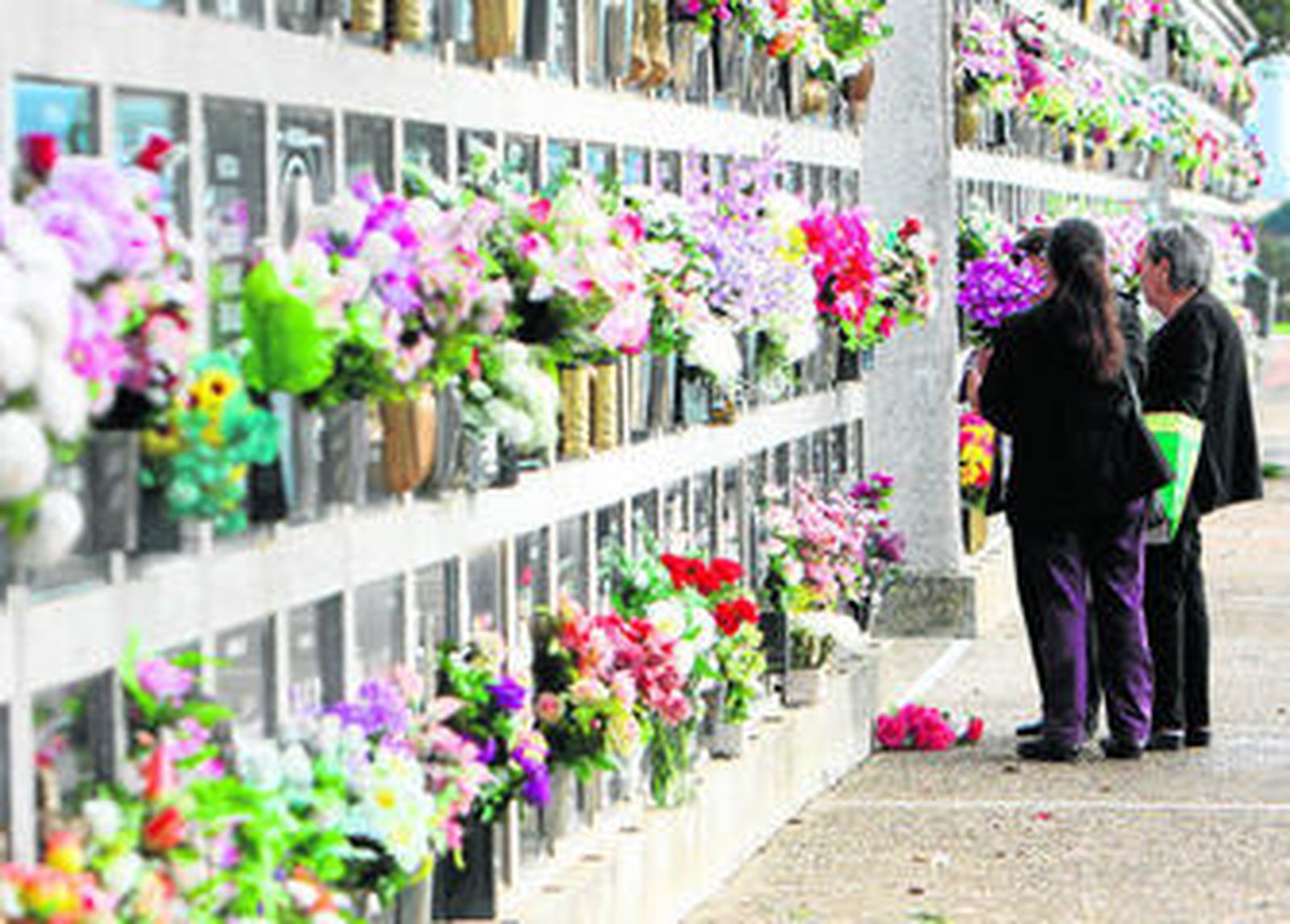 Unas mujeres  delante de unos nichos en el cementerio Mancomunado de la Bahía de Cádiz.